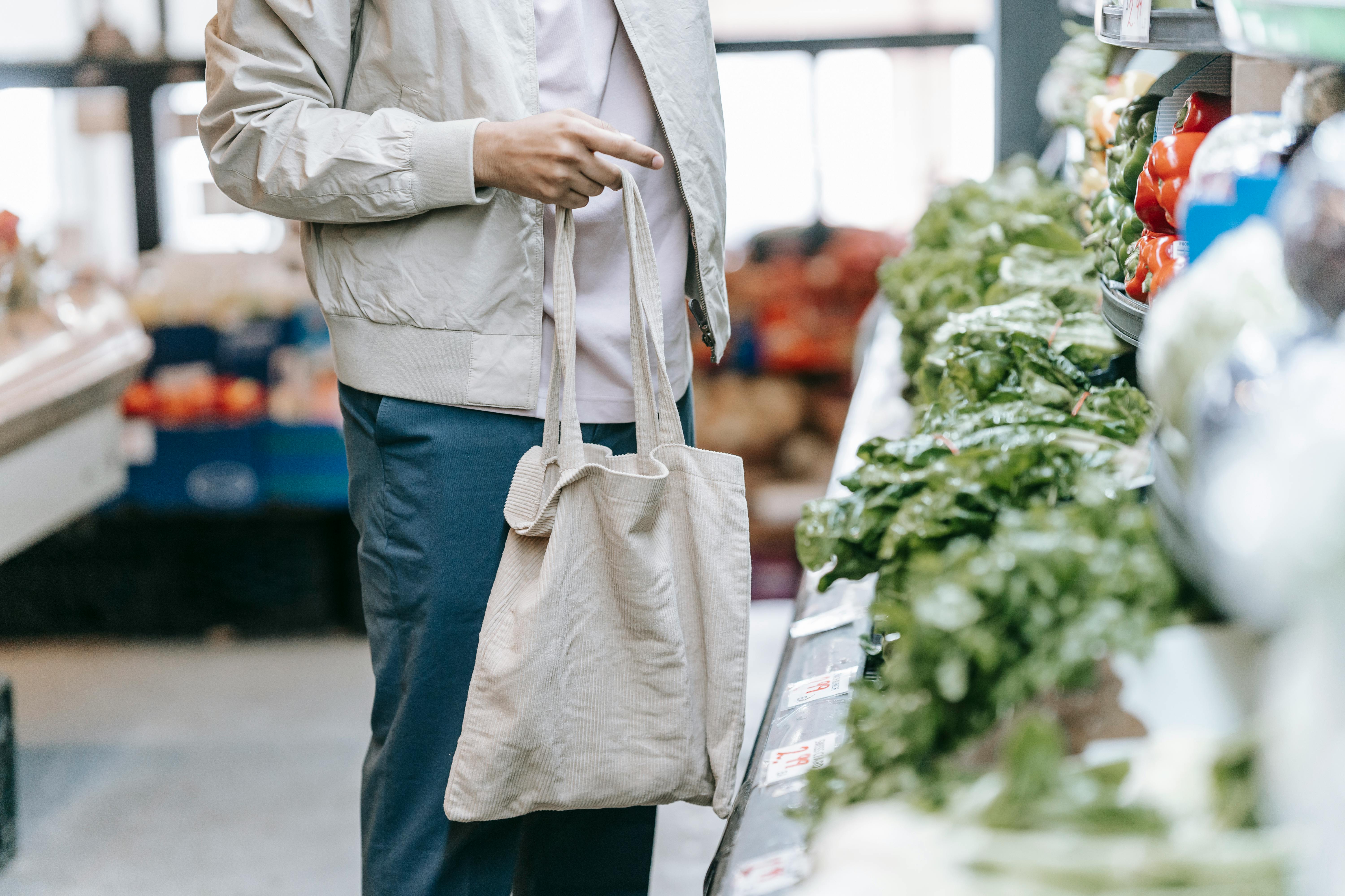 Un homme tenant un sac de courses dans une épicerie | Source : Pexels