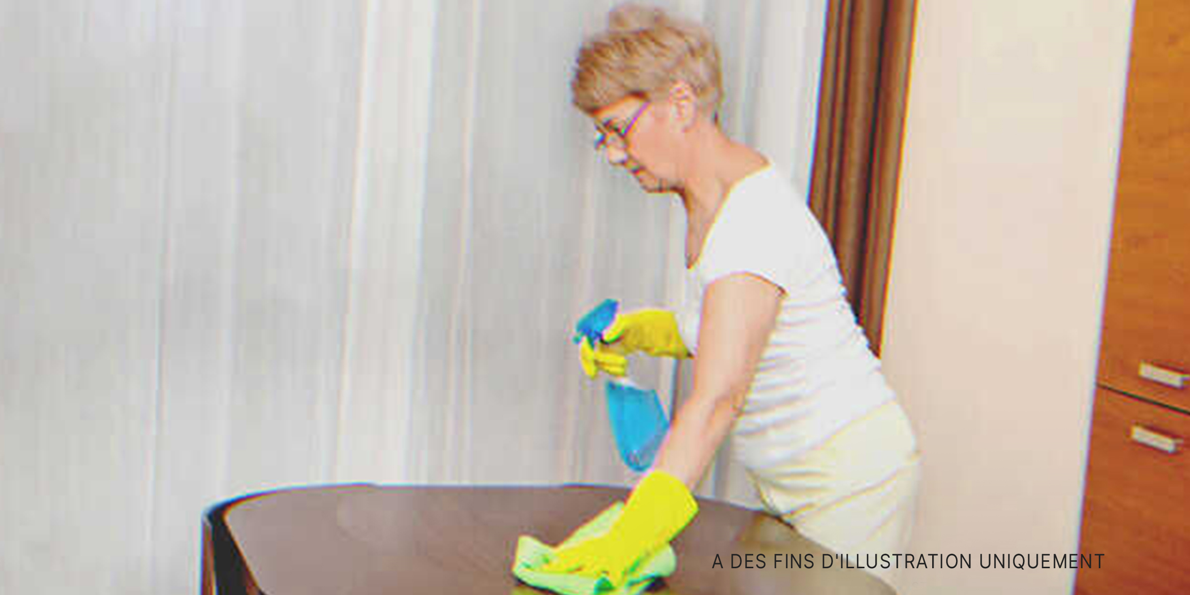 Une femme âgée nettoyant une table. | Source : Shutterstock