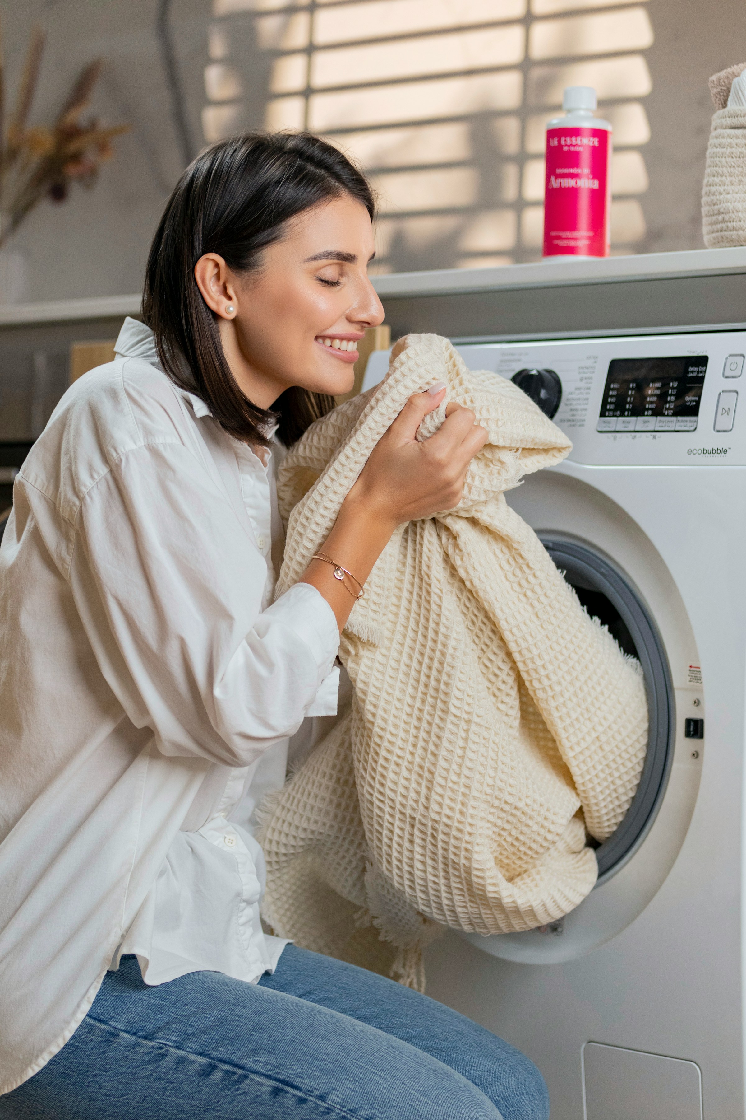 Une femme souriante qui sent le linge lavé | Source : Unsplash