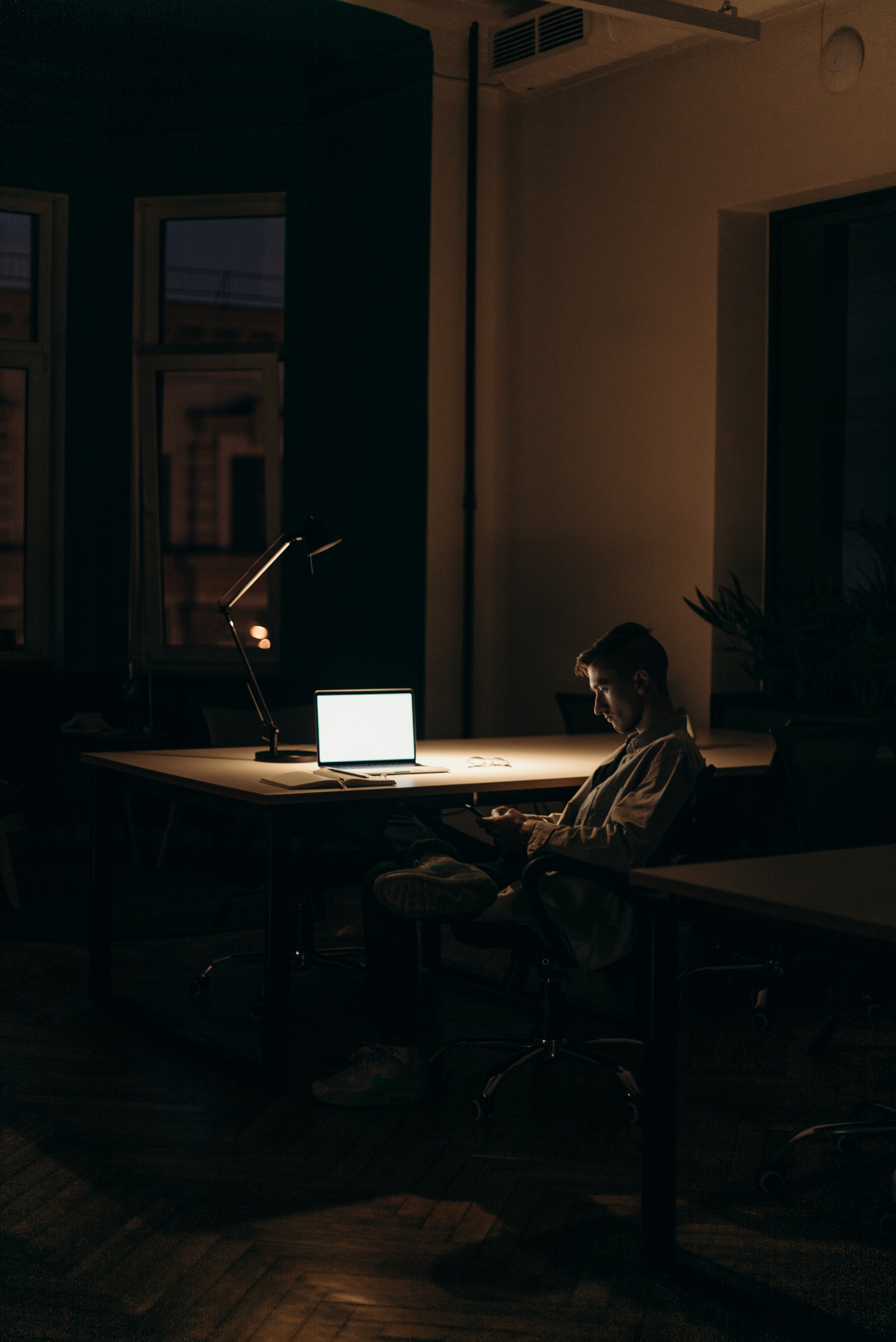 Un homme assis devant un ordinateur portable dans une pièce sombre | Source : Pexels