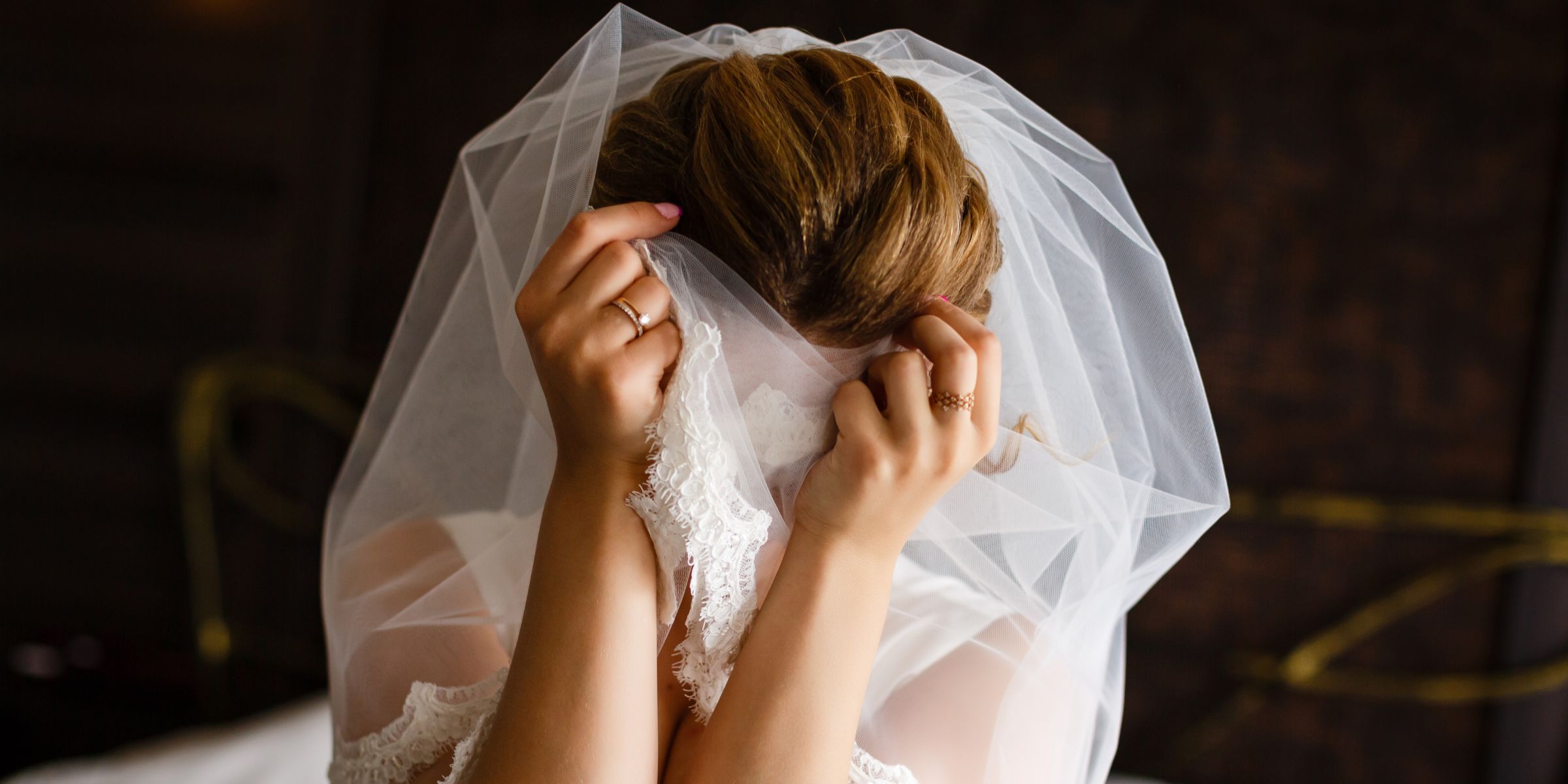 Une mariée misérable se couvrant le visage avec ses mains et son voile | Source : Shutterstock