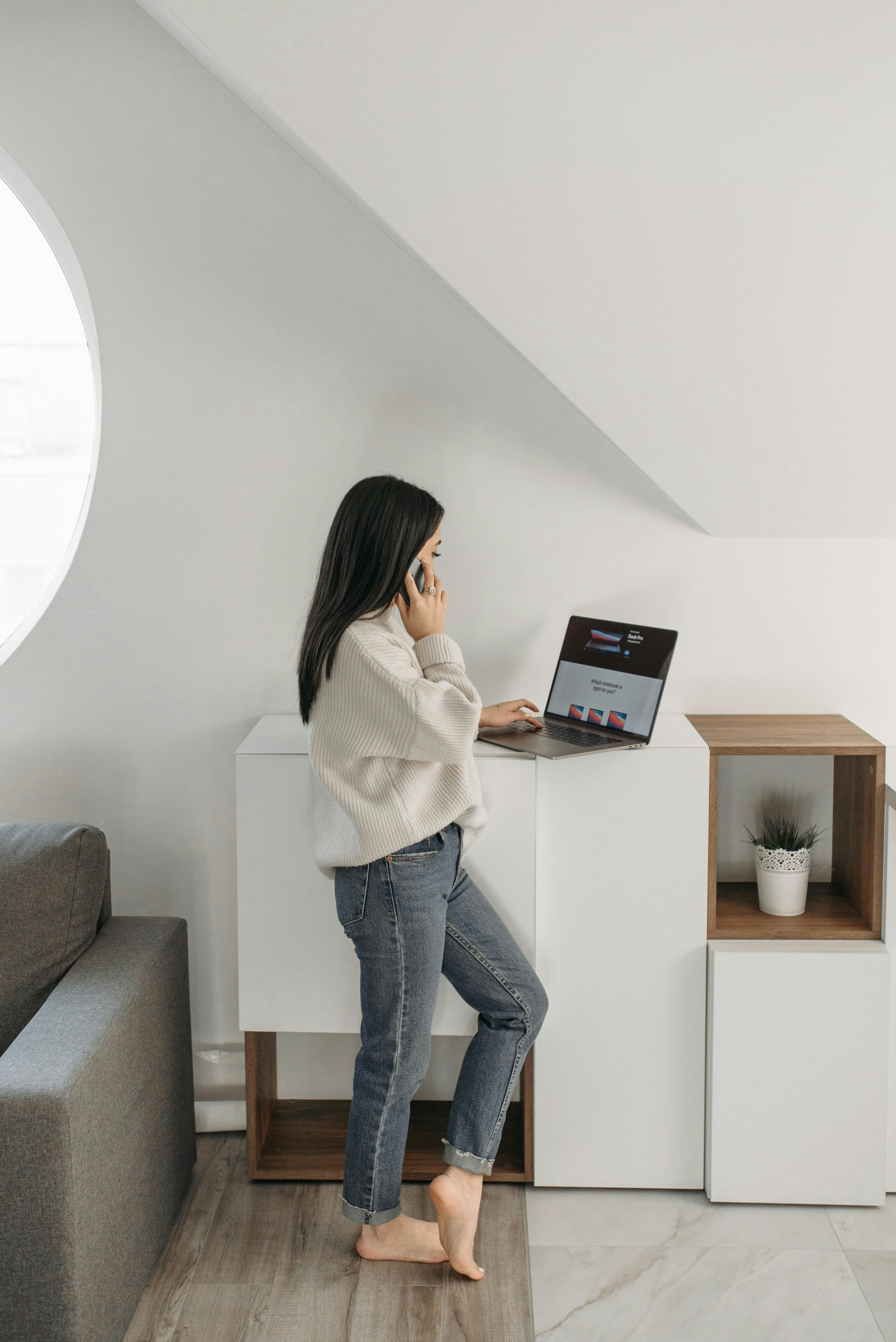Une femme qui parle au téléphone tout en utilisant un ordinateur portable | Source : Pexels