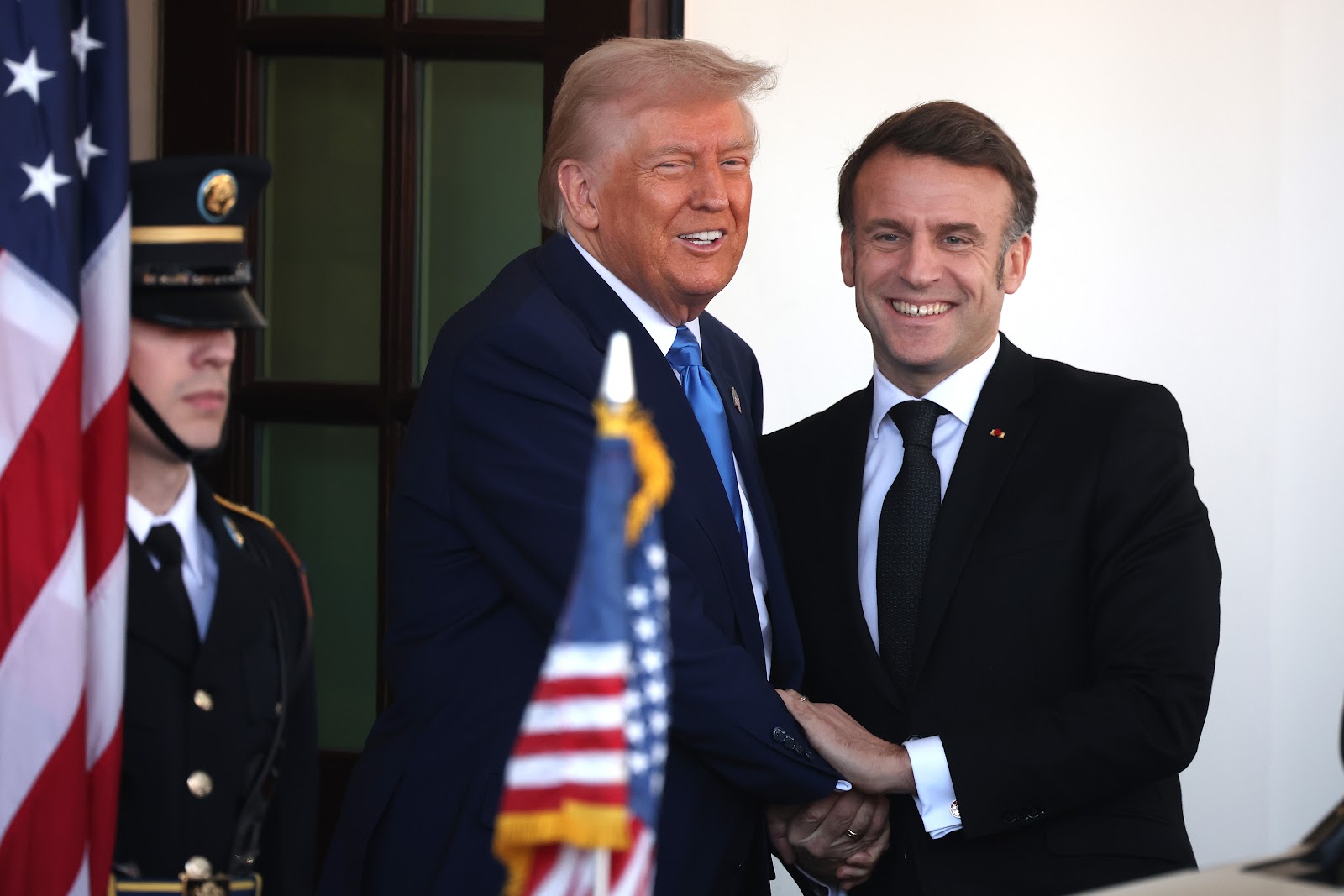 Donald Trump et Emmanuel Macron sourient et se serrent la main. | Source : Getty Images