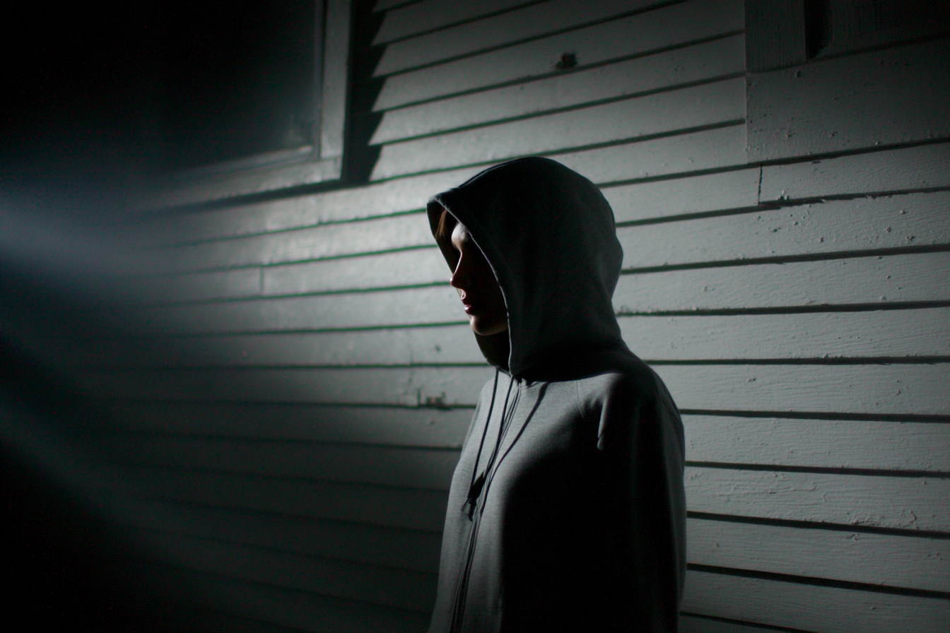 Une personne se tenant près d'une maison la nuit | Source : Midjourney