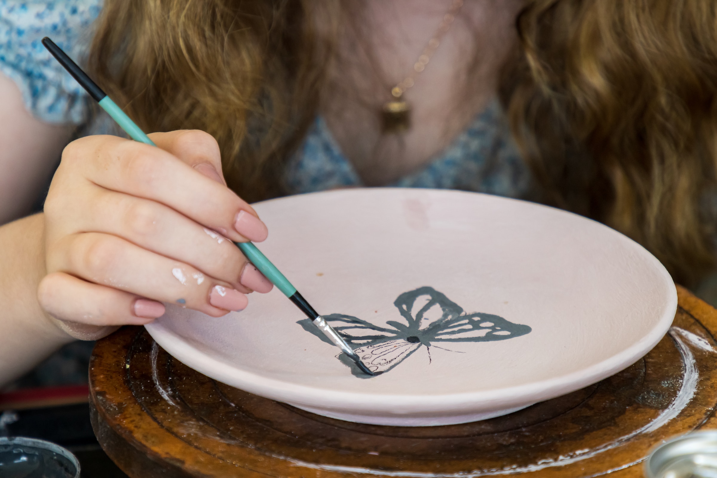 Une personne peignant sur une assiette en poterie | Source : Unsplash