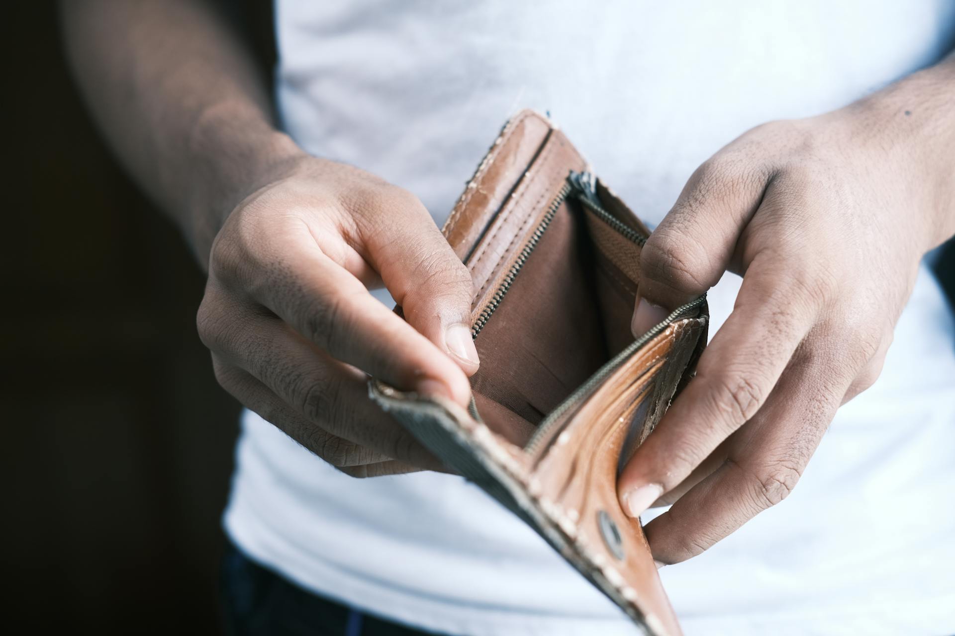 Un homme tenant un portefeuille vide | Source : Pexels
