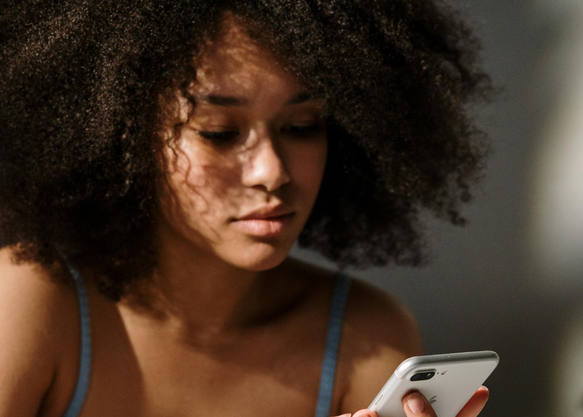 A young woman holding her phone | Source: Pexels