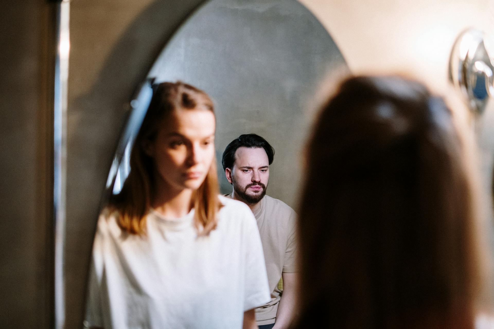 Une femme qui regarde le reflet de son mari dans le miroir de la salle de bain | Source : Pexels