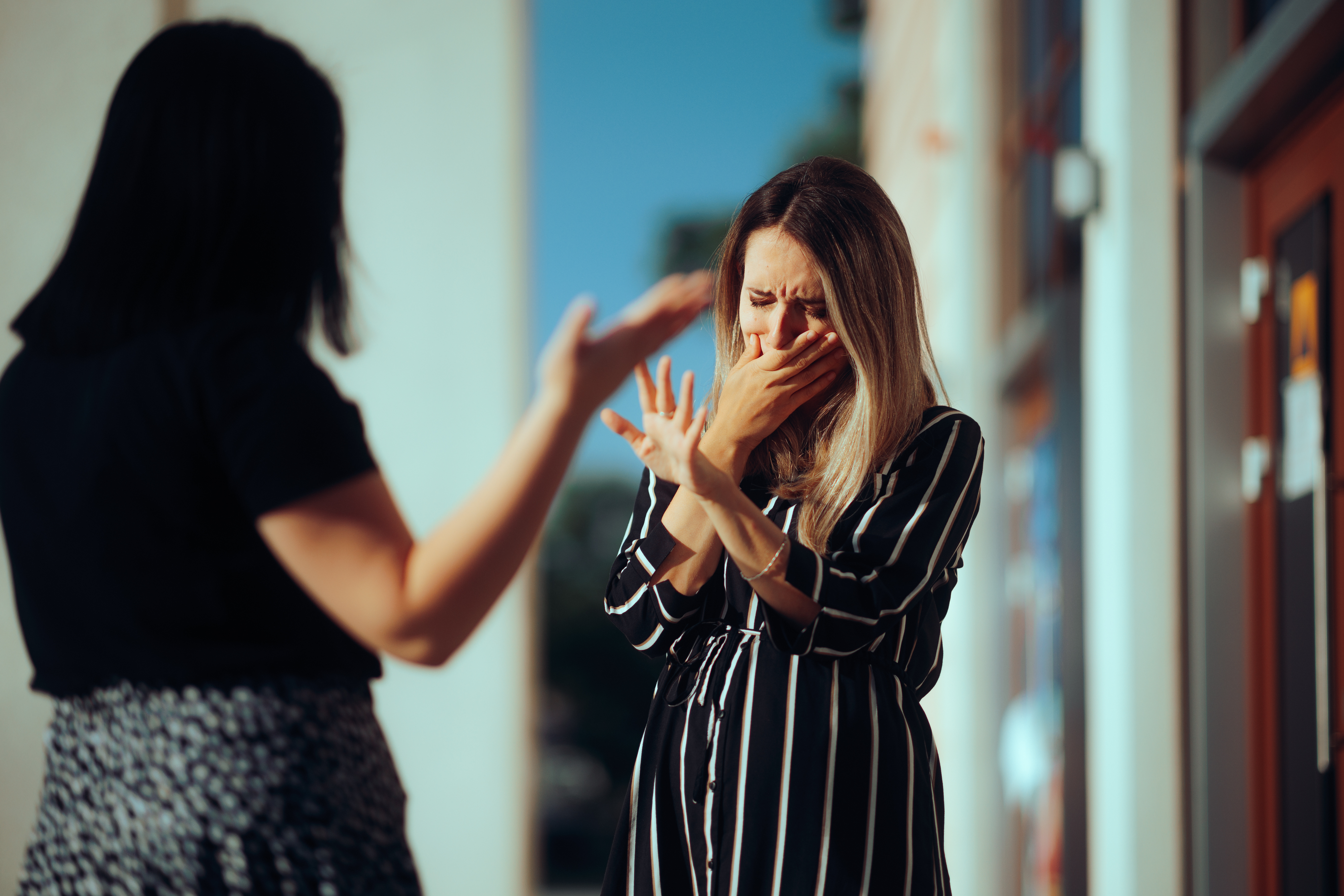 Femme pleurant en se disputant avec son meilleur ami en plein air | Source : Getty Images