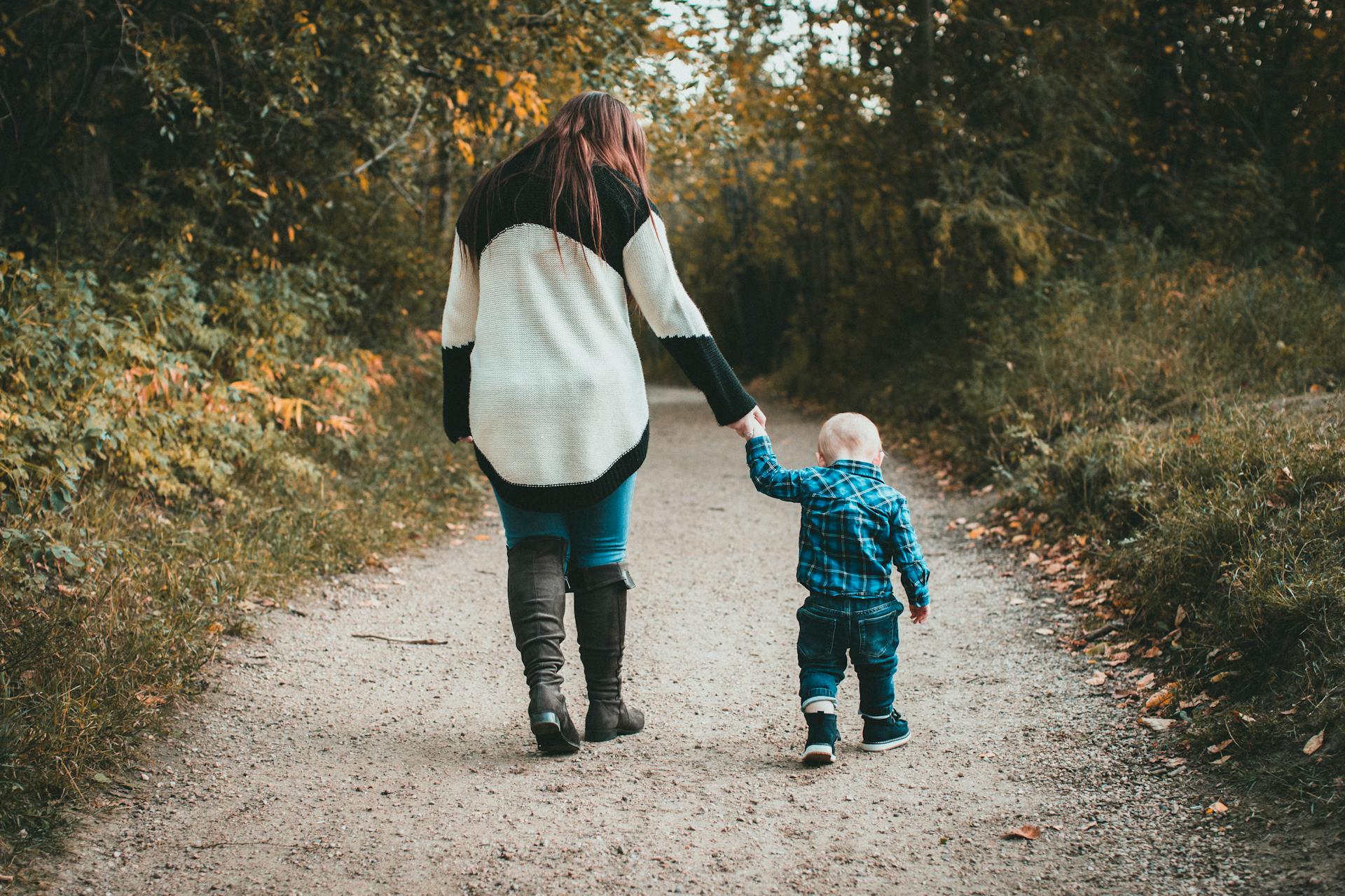 Une femme tenant la main de son petit fils alors qu'ils marchent ensemble | Source : Pexels