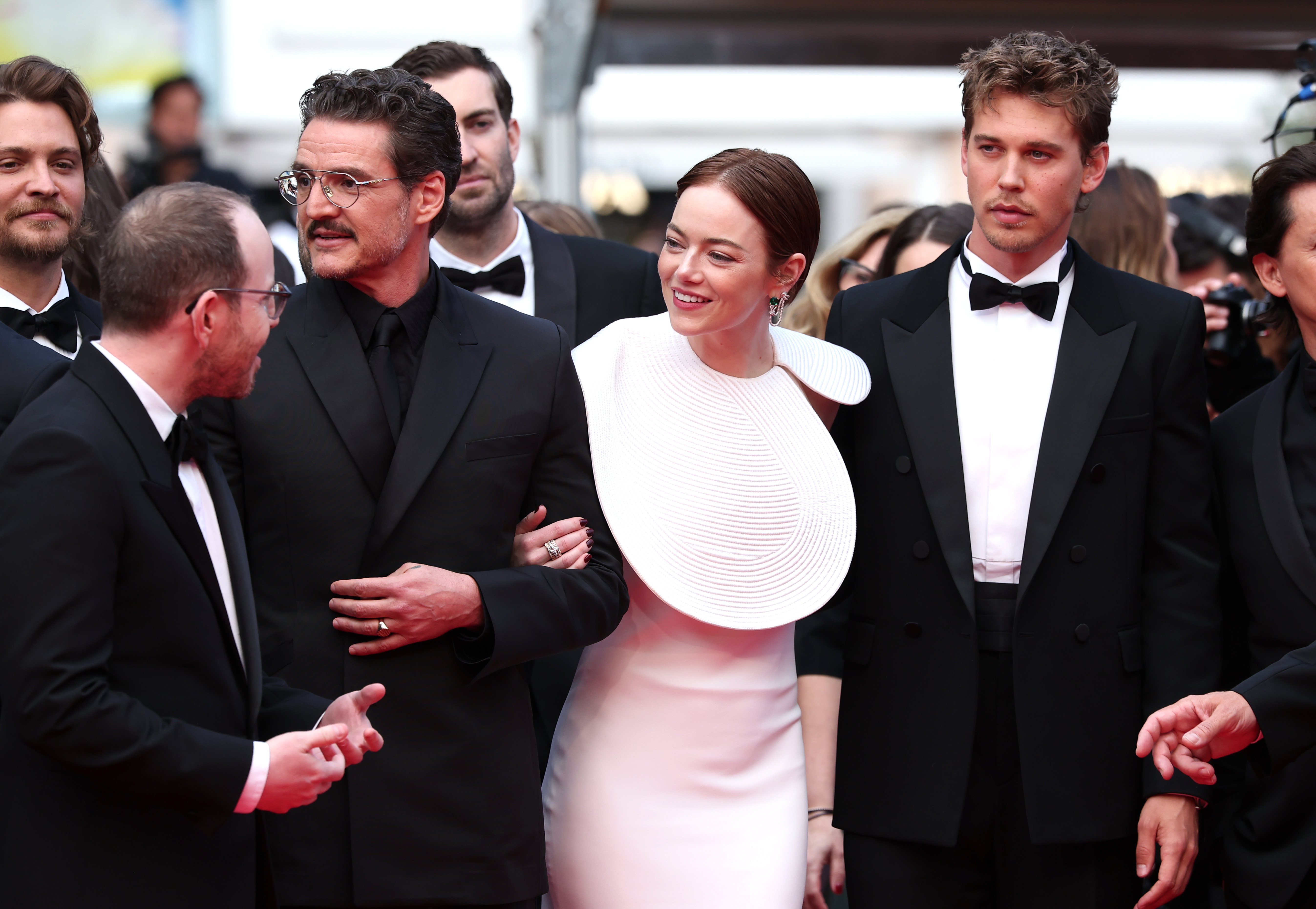 Les acteurs d'"Eddington" partagent un moment de légèreté avant de se rendre à la projection. Emma Stone se lie les bras avec Pedro Pascal sous le regard d'Austin Butler. Leurs ensembles coordonnés en noir et blanc offrent un style raffiné sur le tapis rouge.