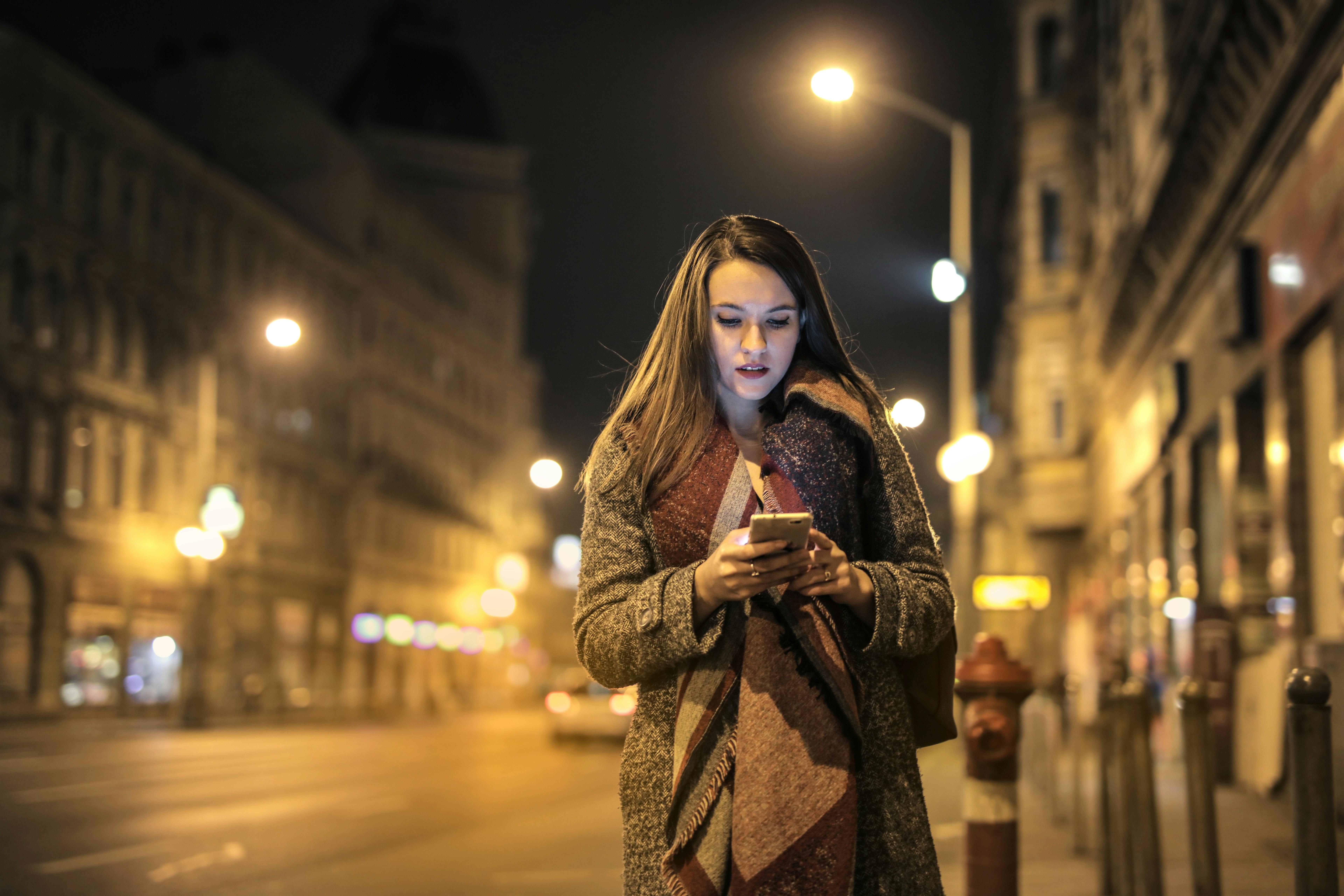 Une femme en train de regarder son téléphone portable au milieu d'une rue | Source : Pexels