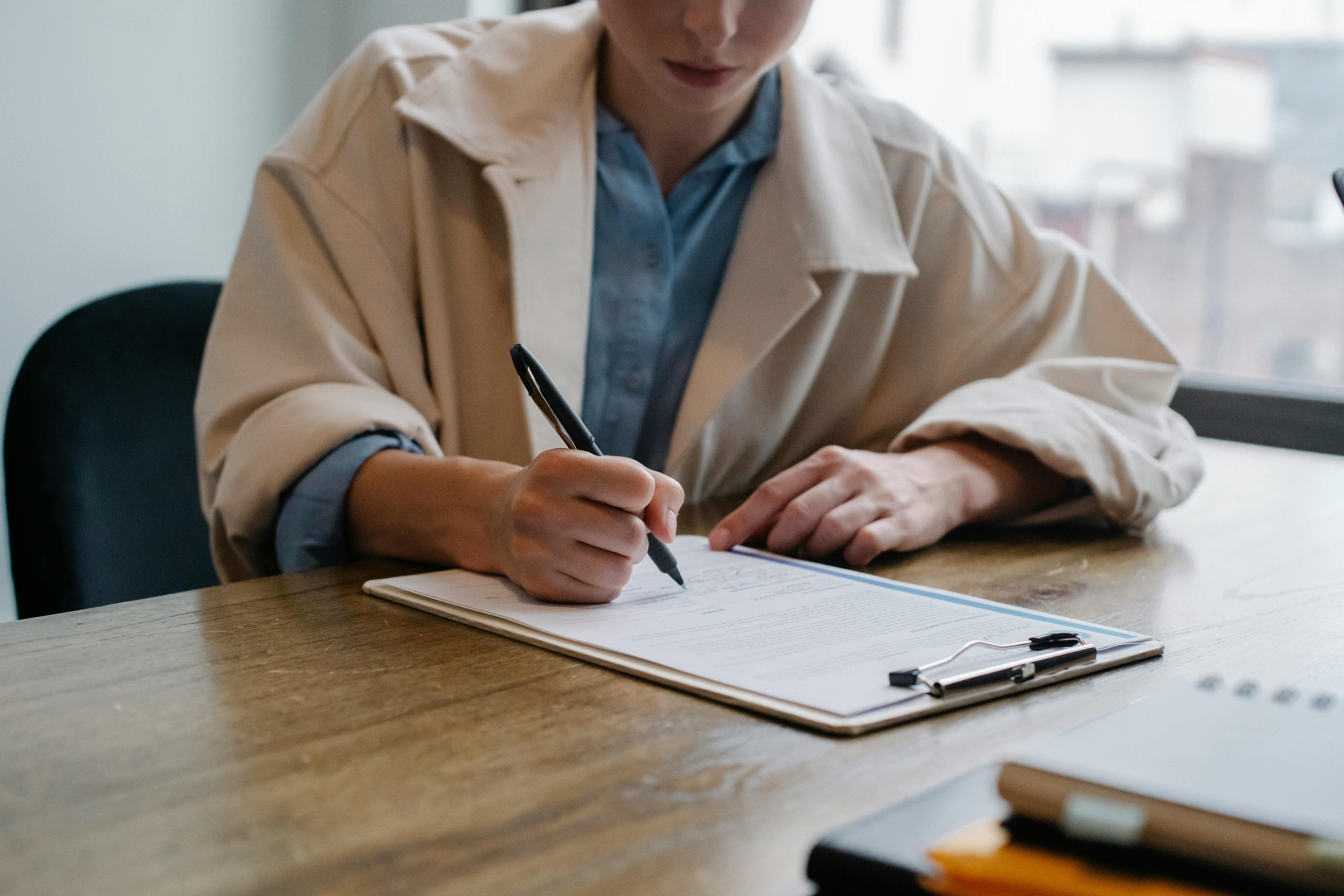 Une femme remplissant des documents administratifs | Source : Pexels