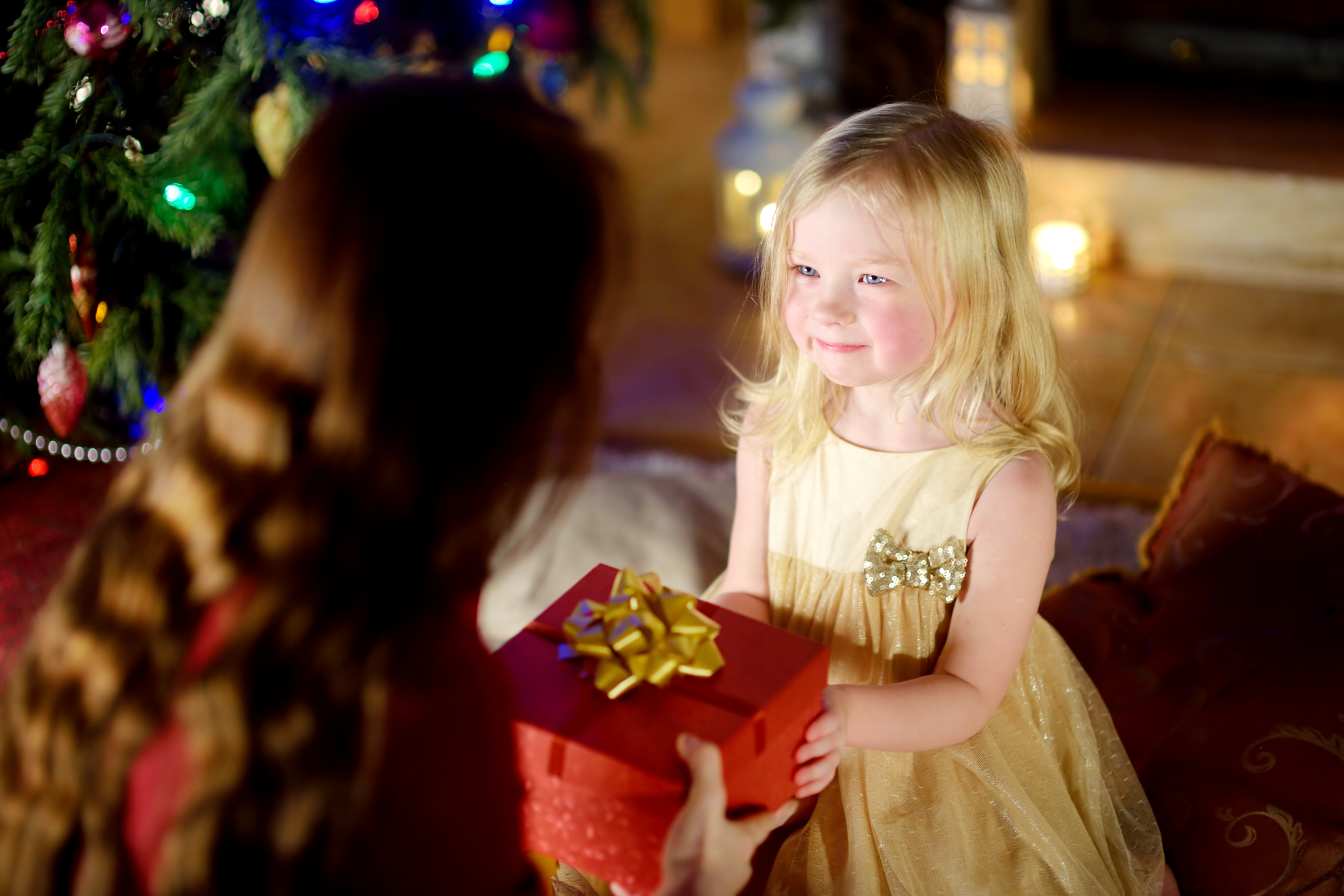 Une petite fille heureuse qui reçoit un cadeau de Noël de sa mère | Source : Getty Images