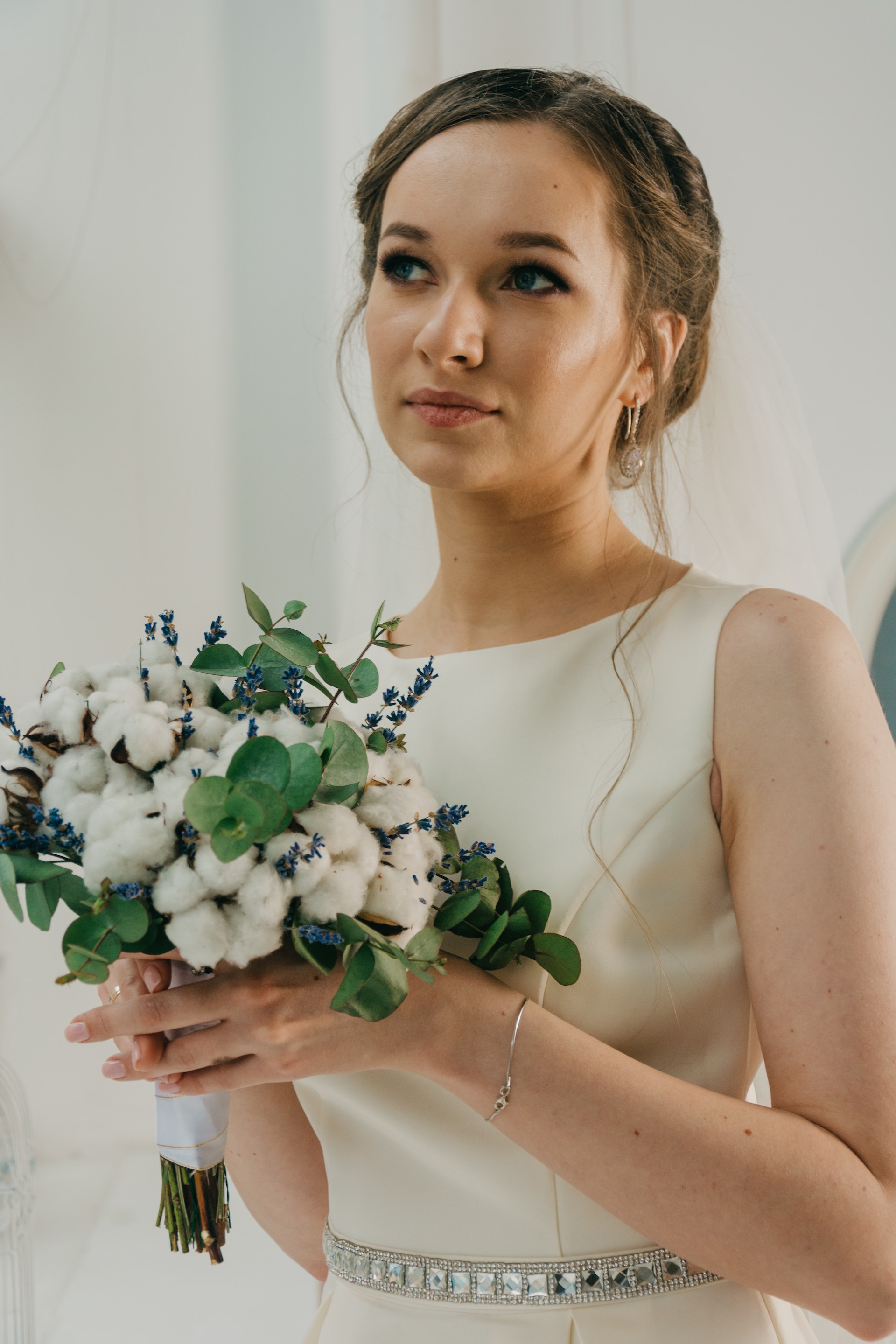 Une femme en robe blanche tenant un bouquet de fleurs | Source : Pexels