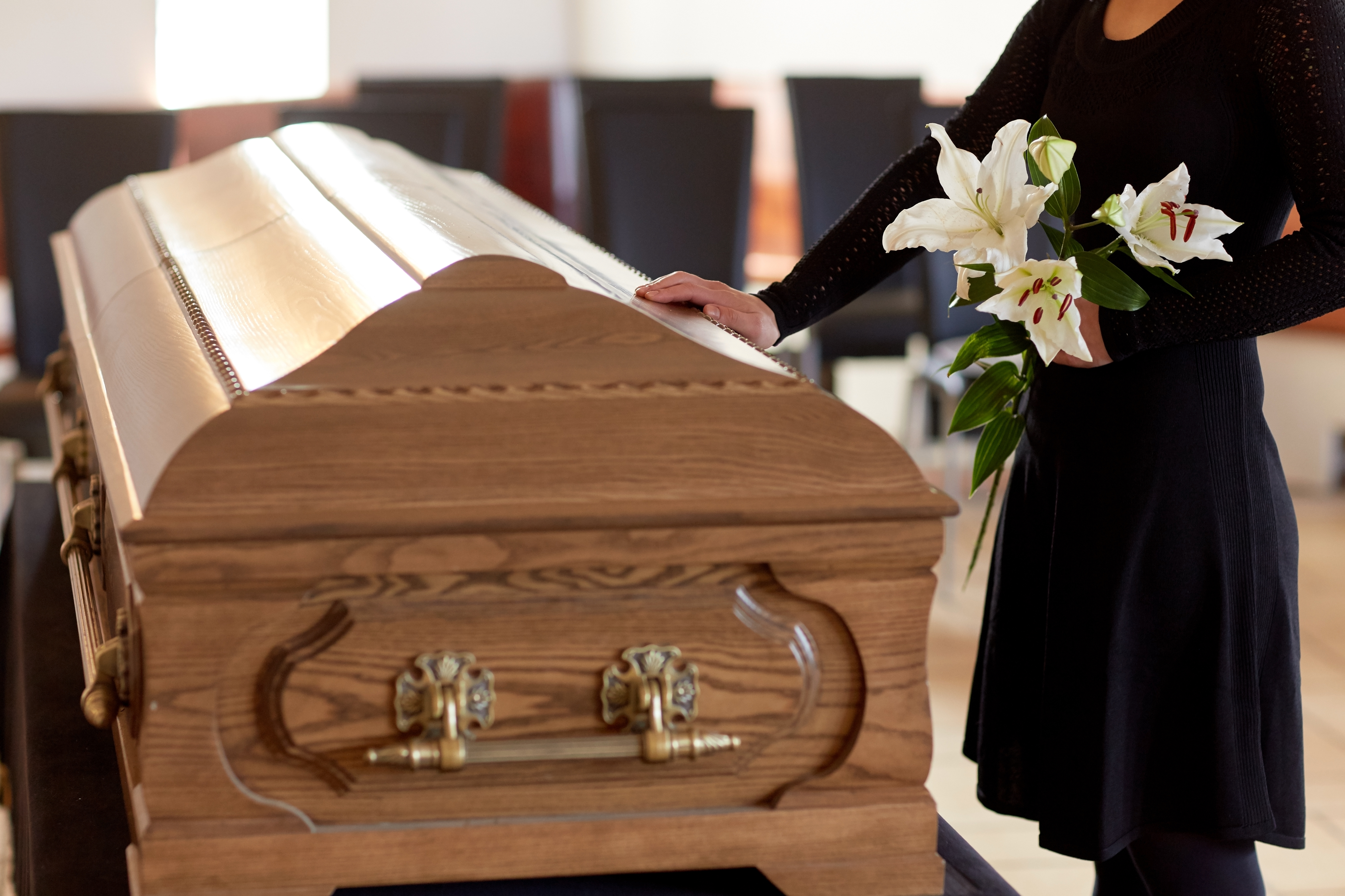 Une femme debout à côté d'un cercueil | Source : Shutterstock