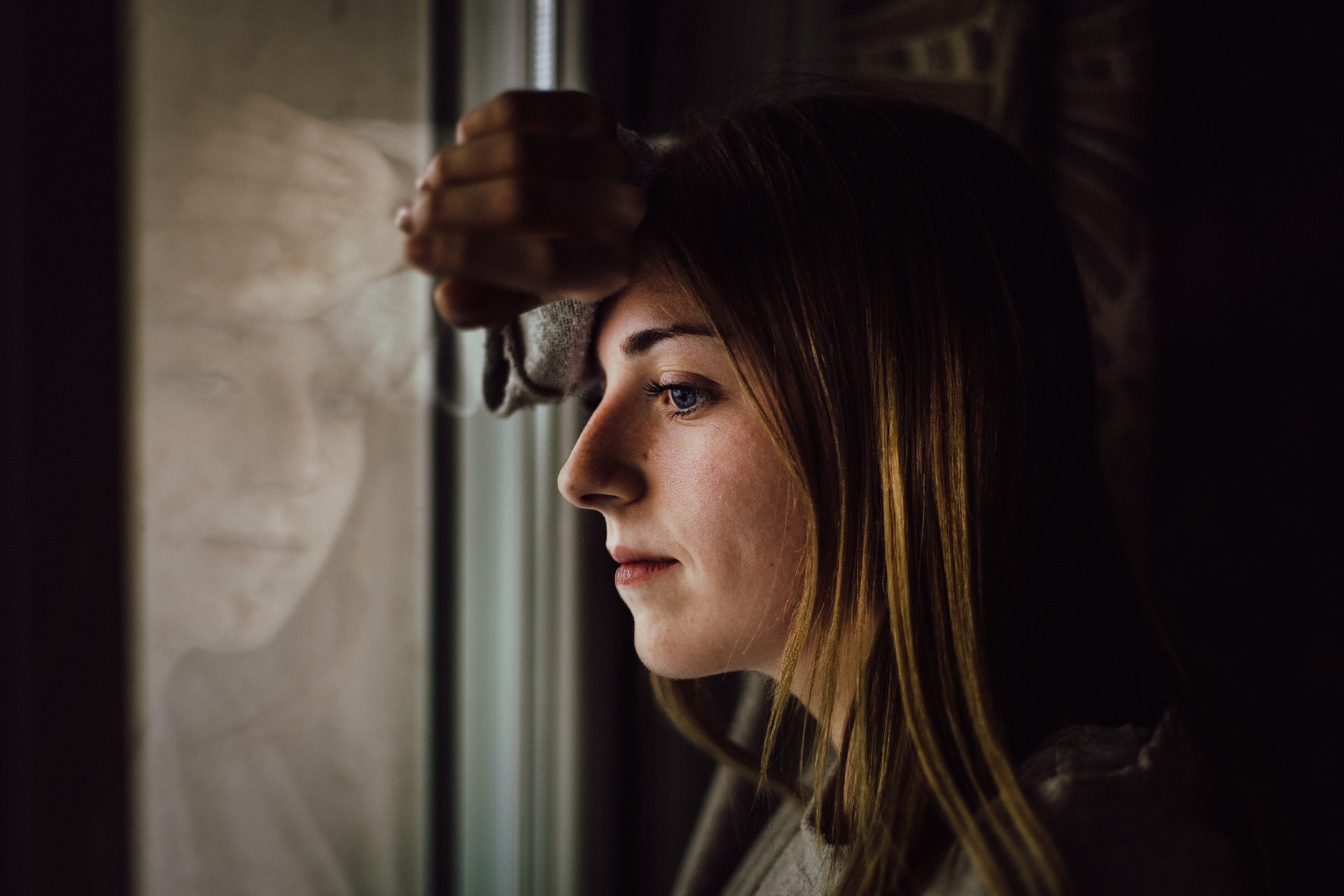 Une femme regardant par fenêtre | Source : Pexels