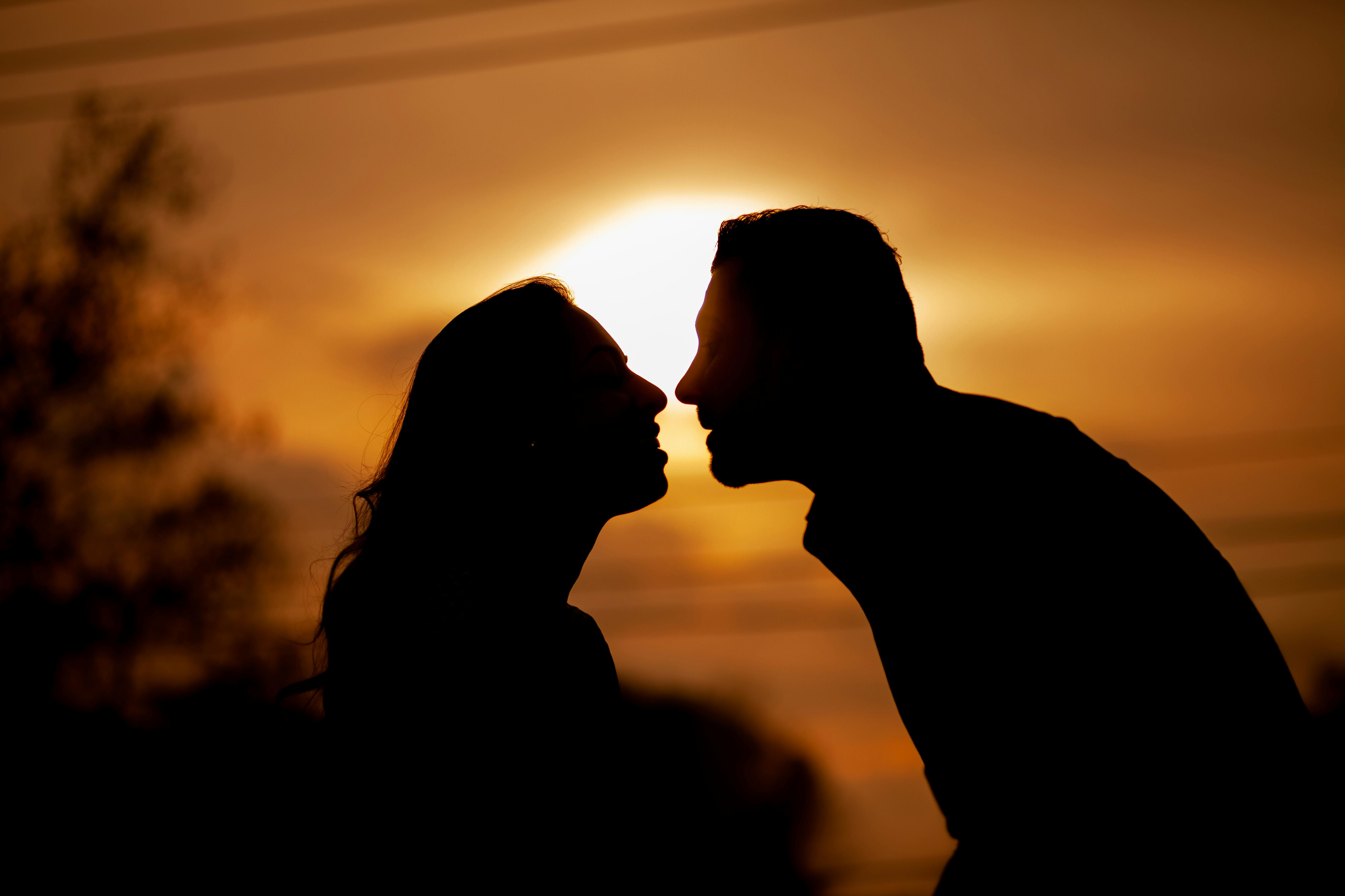 Silhouette d'un couple heureux profitant du coucher de soleil | Source : Pexels