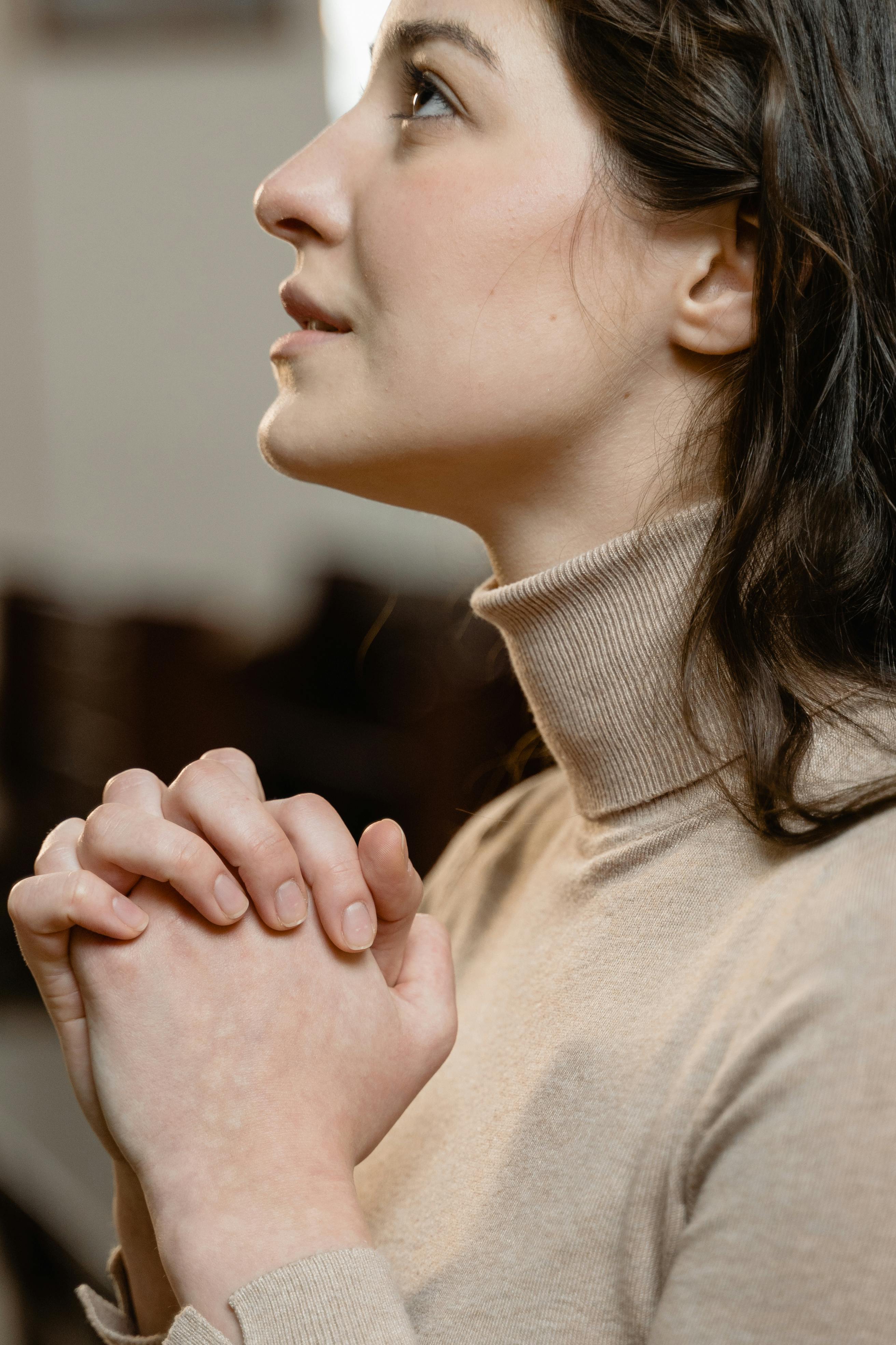 Une femme pleine d'espoir en train de prier | Source : Pexels