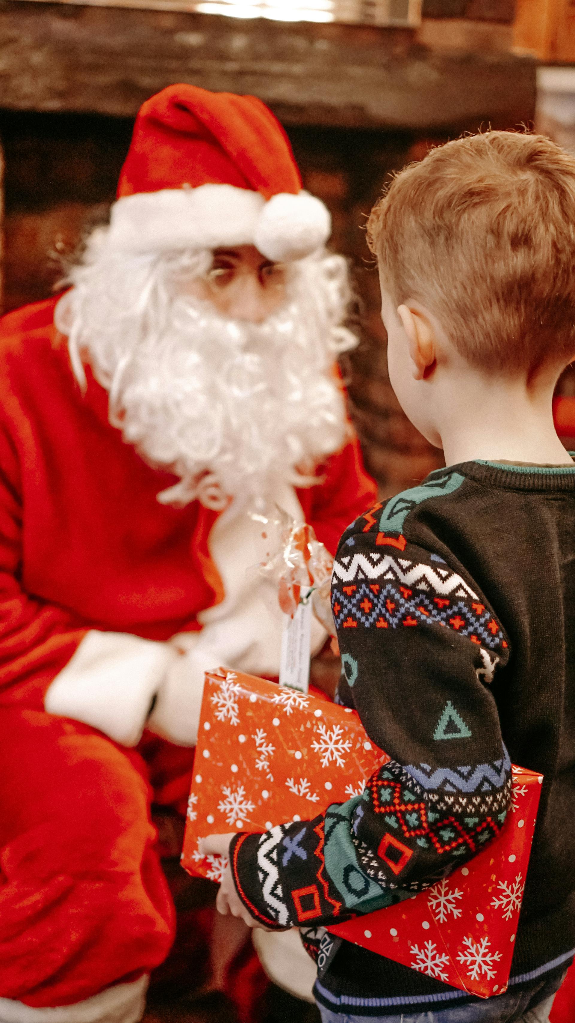 Un petit garçon reçoit un cadeau du Père Noël le jour de Noël | Source : Pexels