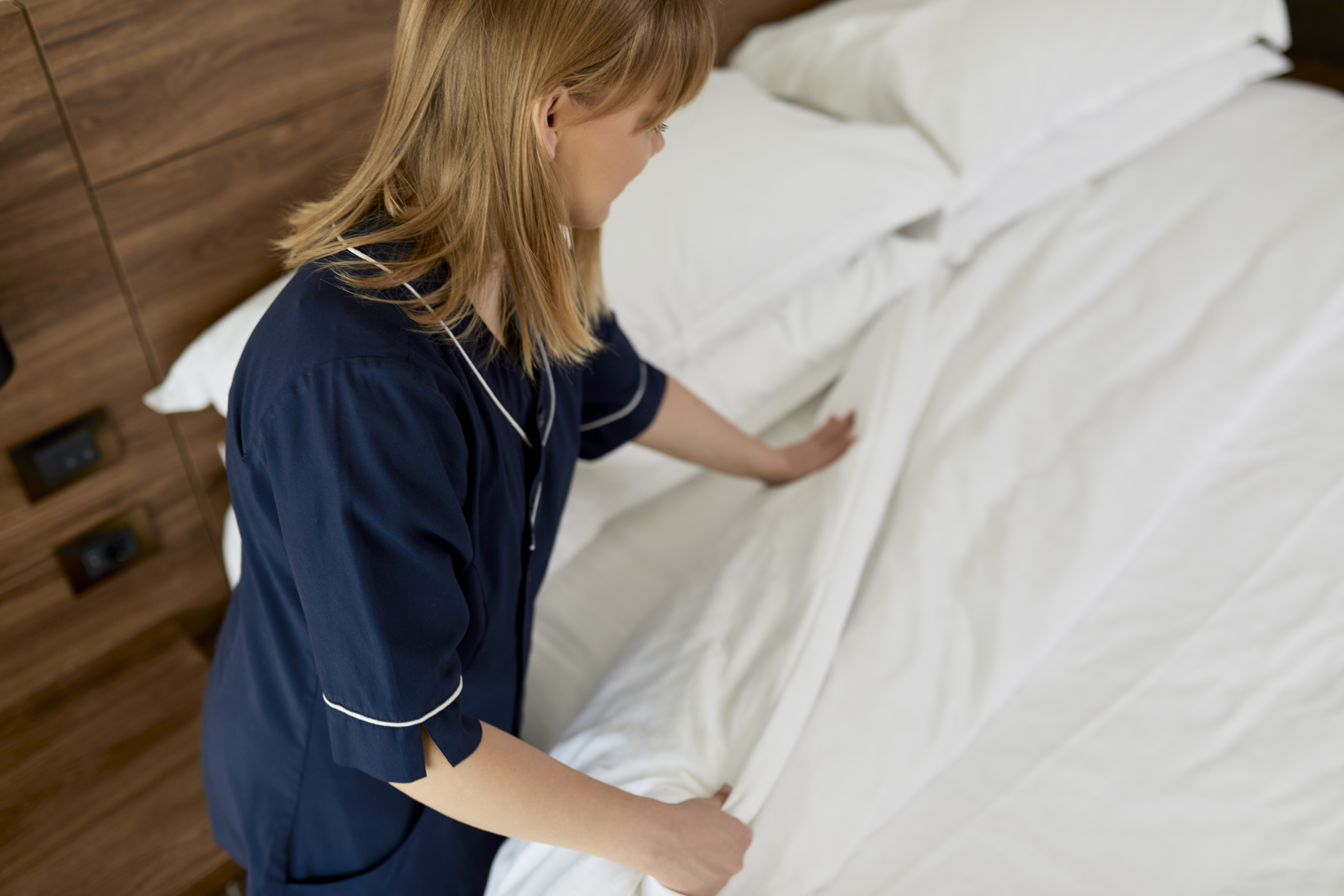 Camareira do hotel arruma a cama | Fonte: Getty Images