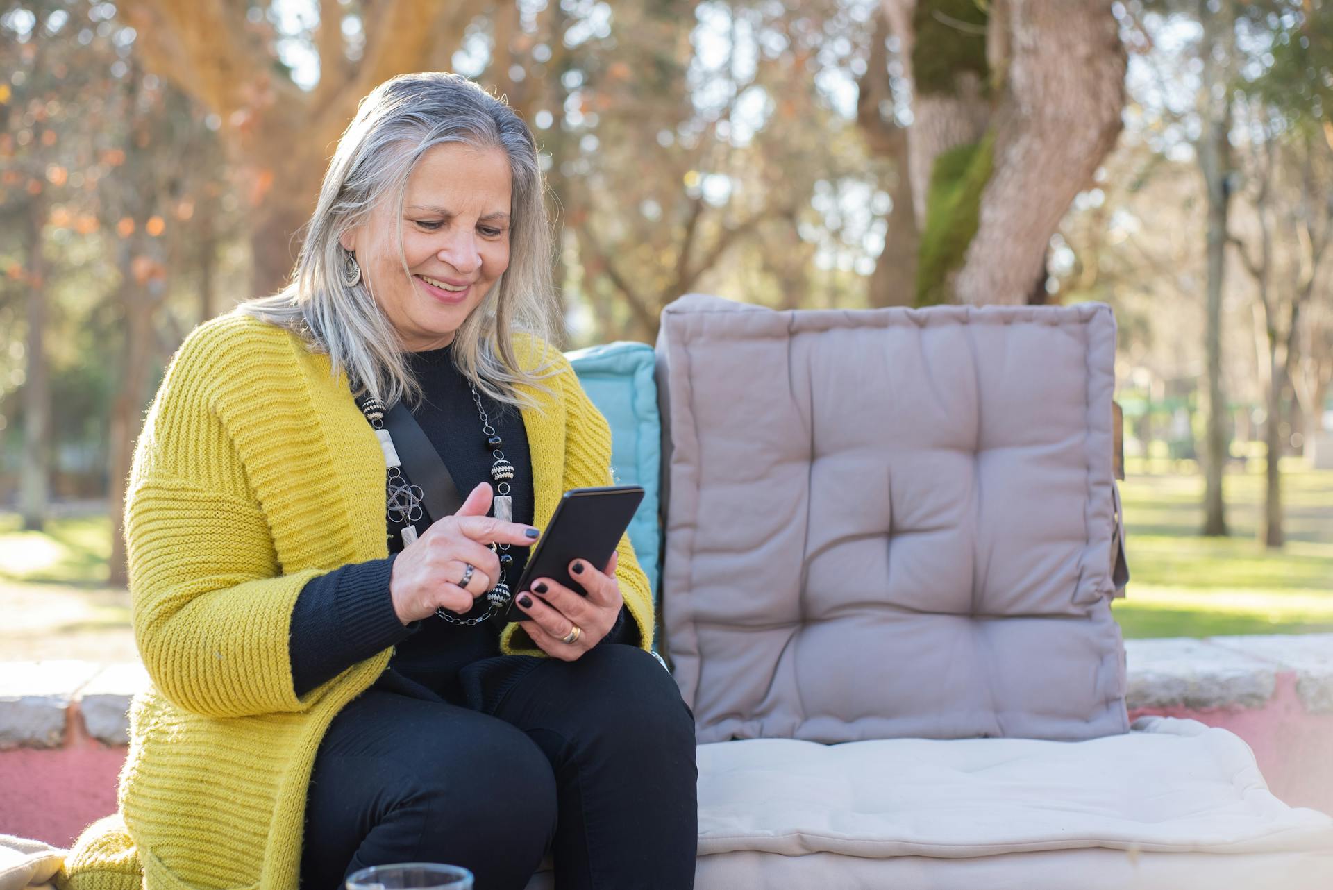 Une femme heureuse utilisant son smartphone | Source : Pexels