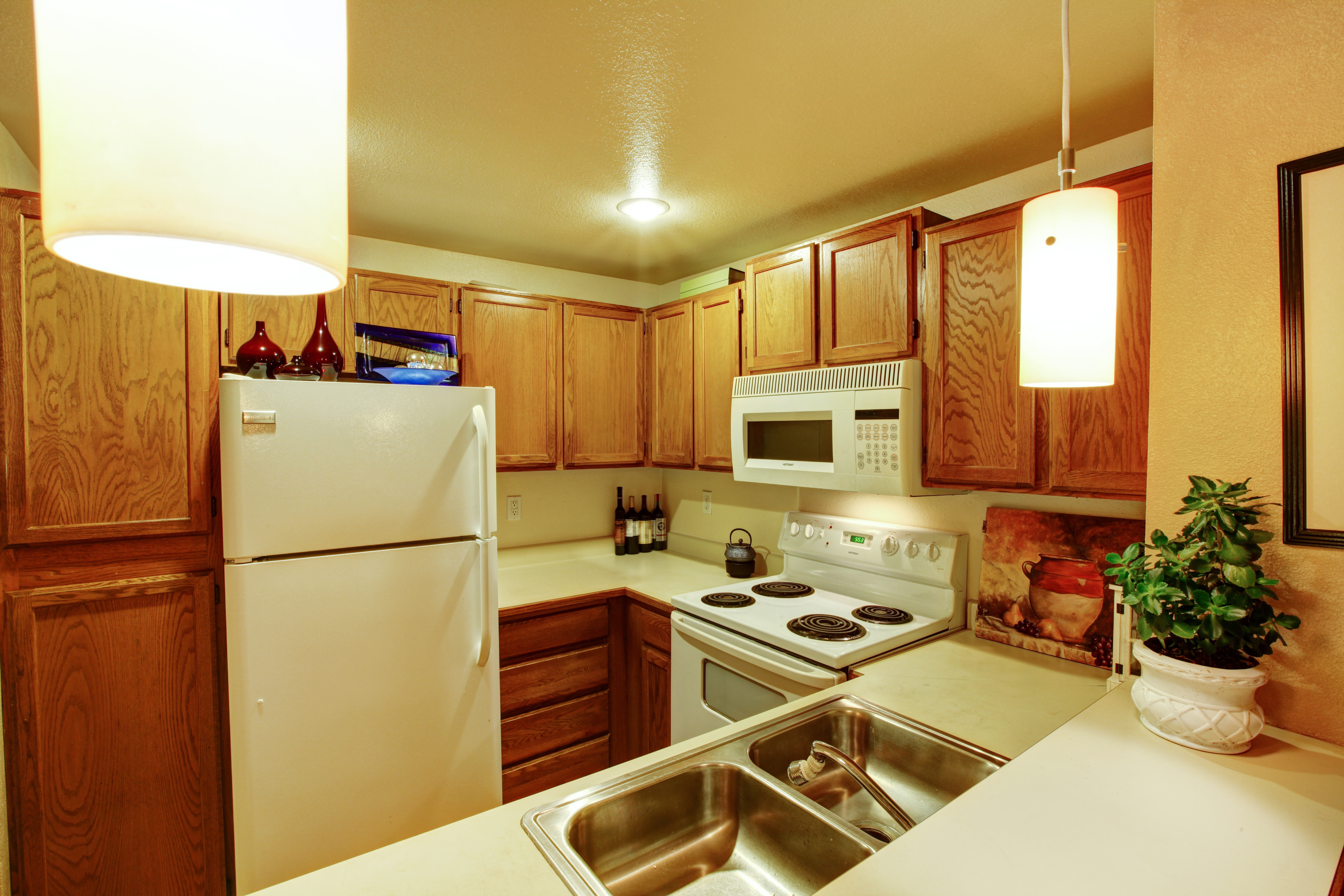 Une vue des armoires de cuisine avec un évier et de vieux appareils électroménagers blancs | Source : Shutterstock