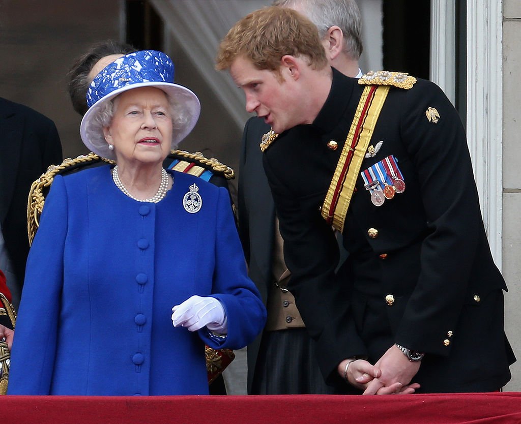 Le prince Harry photographié en train de discuter avec la reine Elizabeth II sur le balcon du palais de Buckingham lors de la cérémonie annuelle du Trooping the Colour le 15 juin 2013 à Londres, en Angleterre. | Source : Getty Images