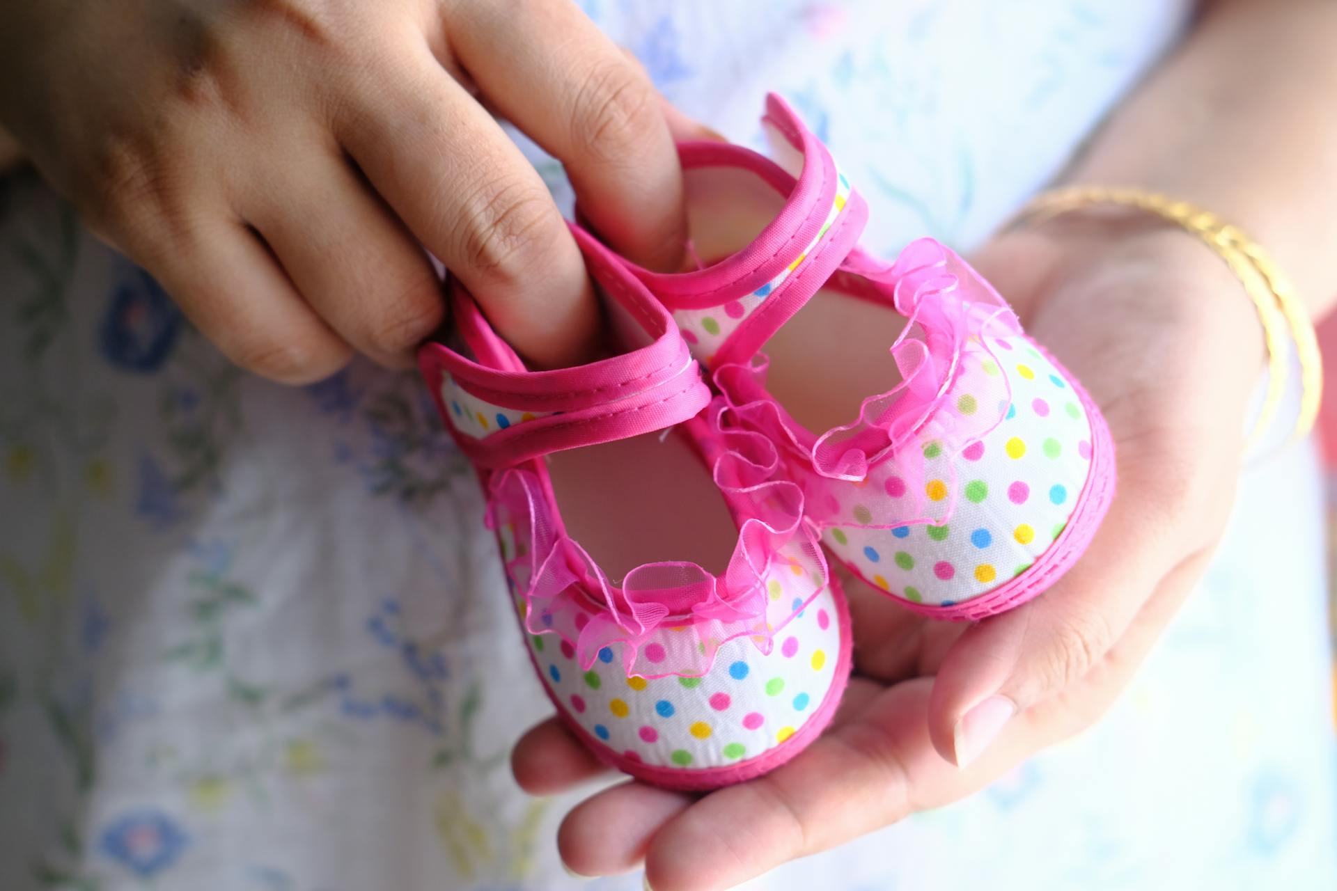 Une femme tenant des chaussures roses pour bébé | Source : Pexels