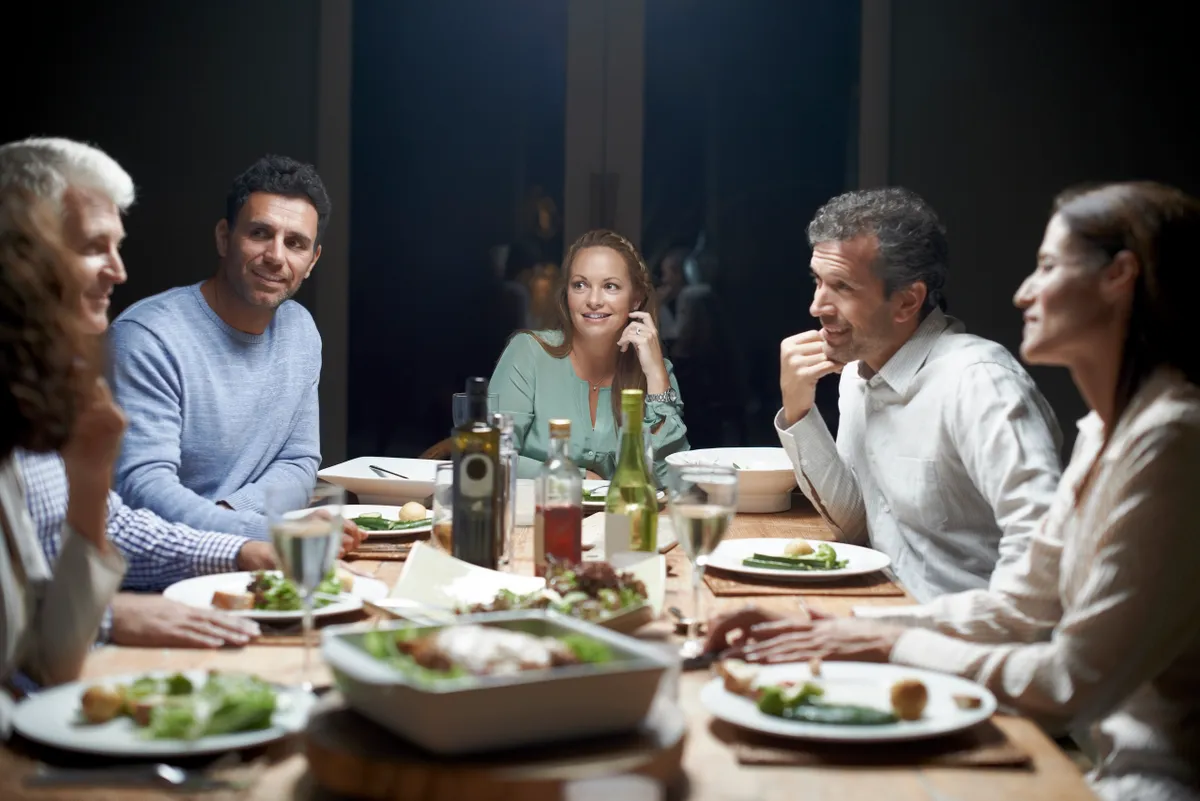 Des gens discutent en dînant | Source : Getty Images