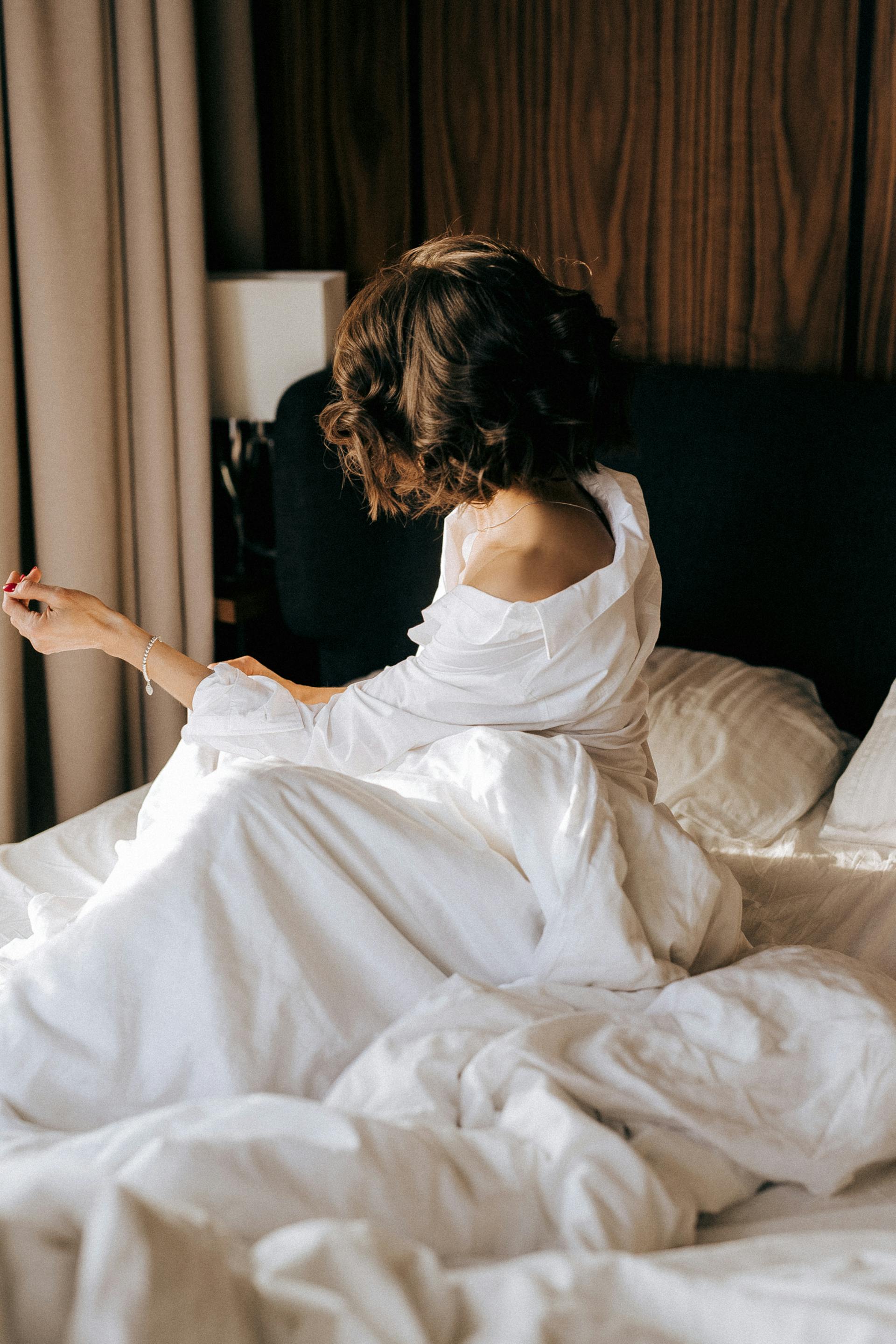 Une femme assise dans son lit | Source : Pexels
