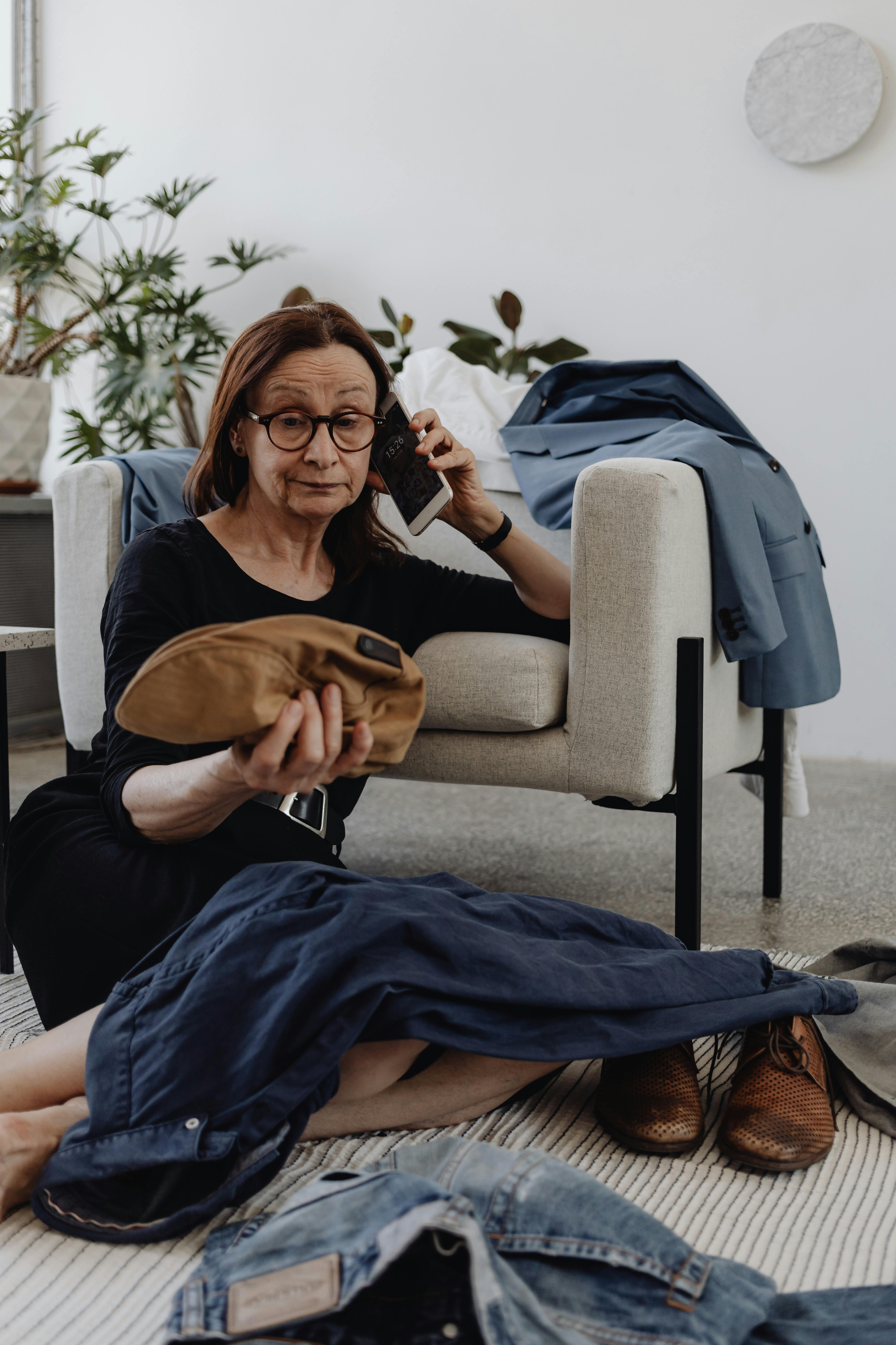 Une femme qui parle au téléphone tout en étant assise par terre | Source : Pexels