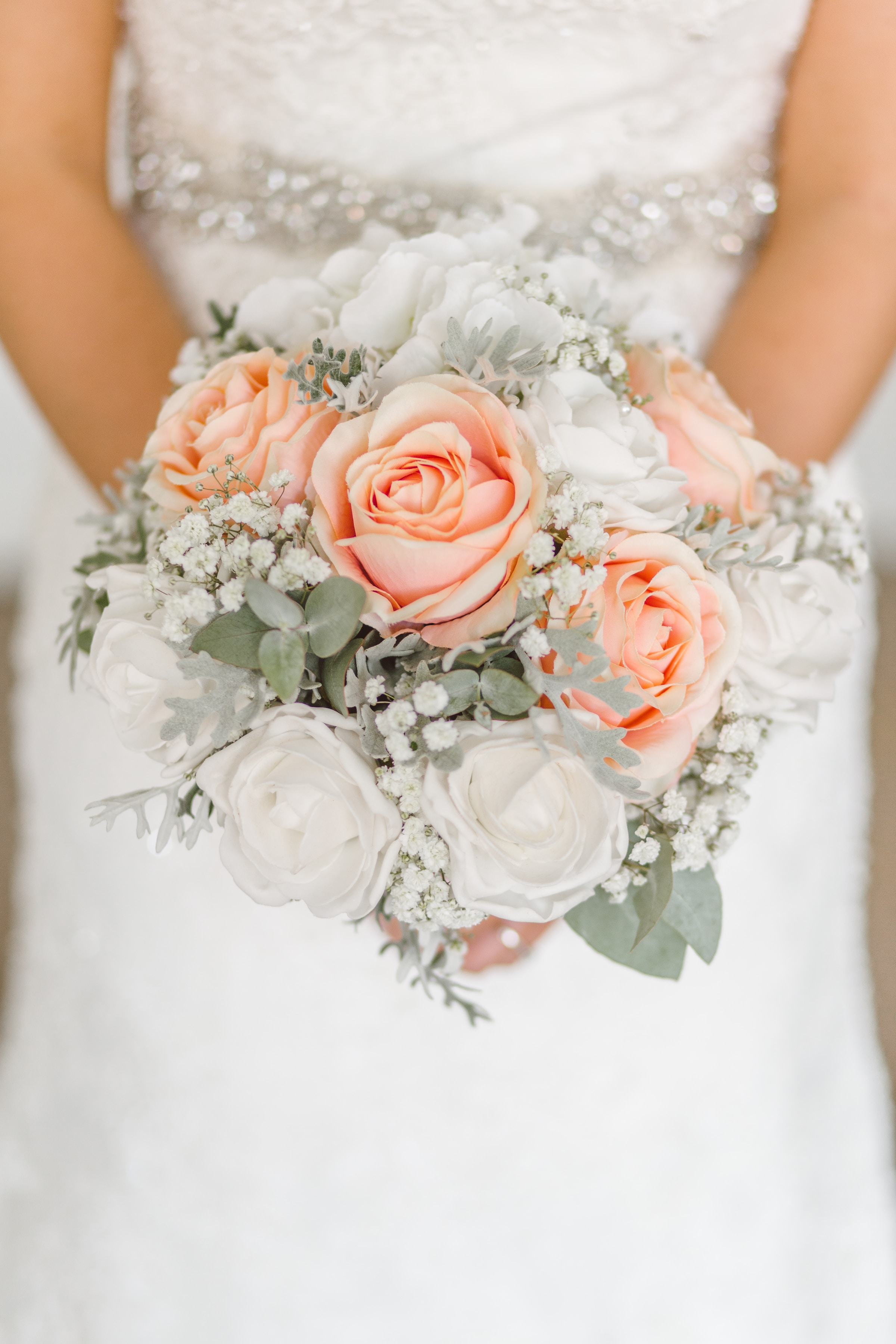 Une mariée en robe de mariée blanche tenant des fleurs | Source : Unsplash
