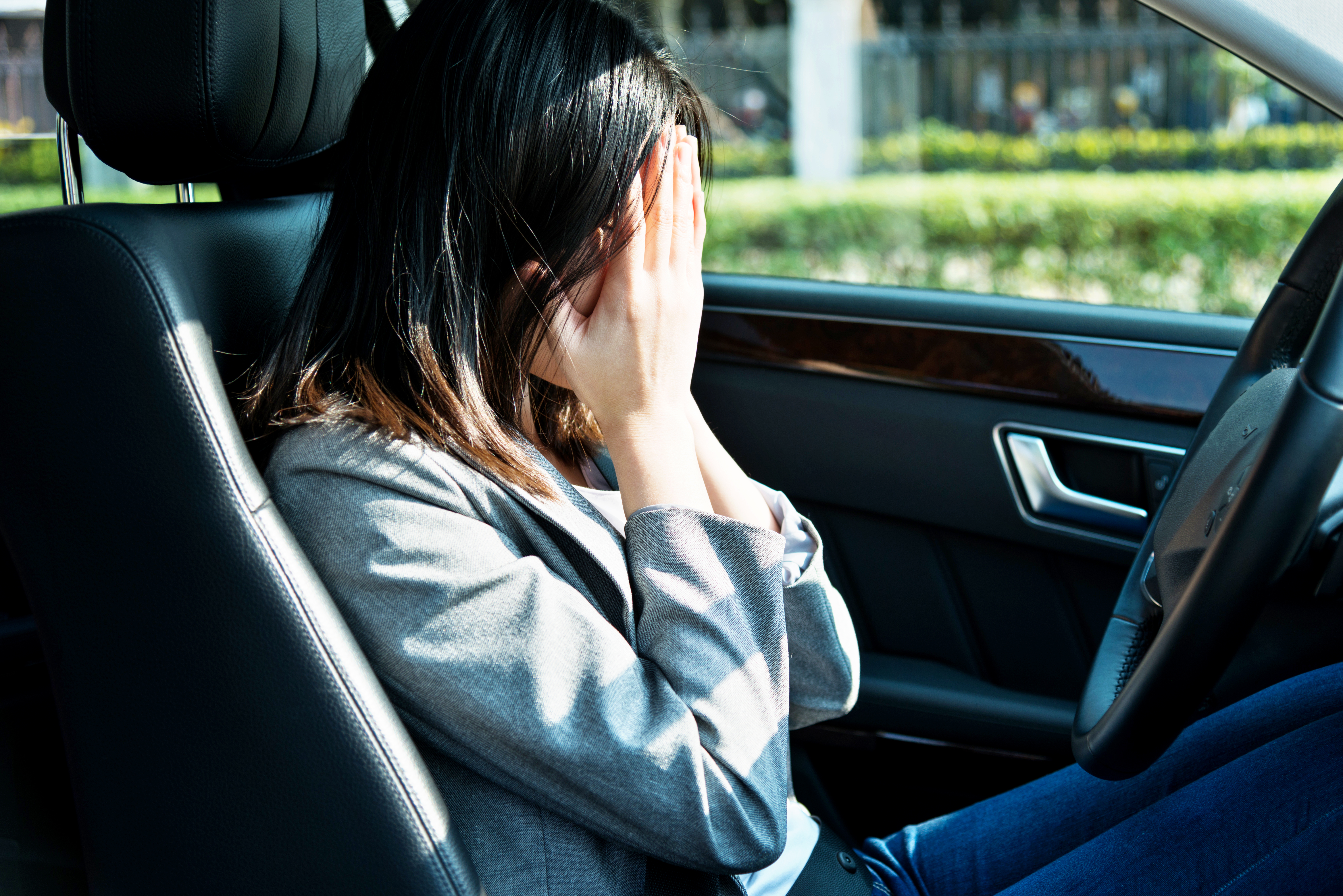 Femme d'affaires triste, assise dans sa voiture | Source : Getty Images