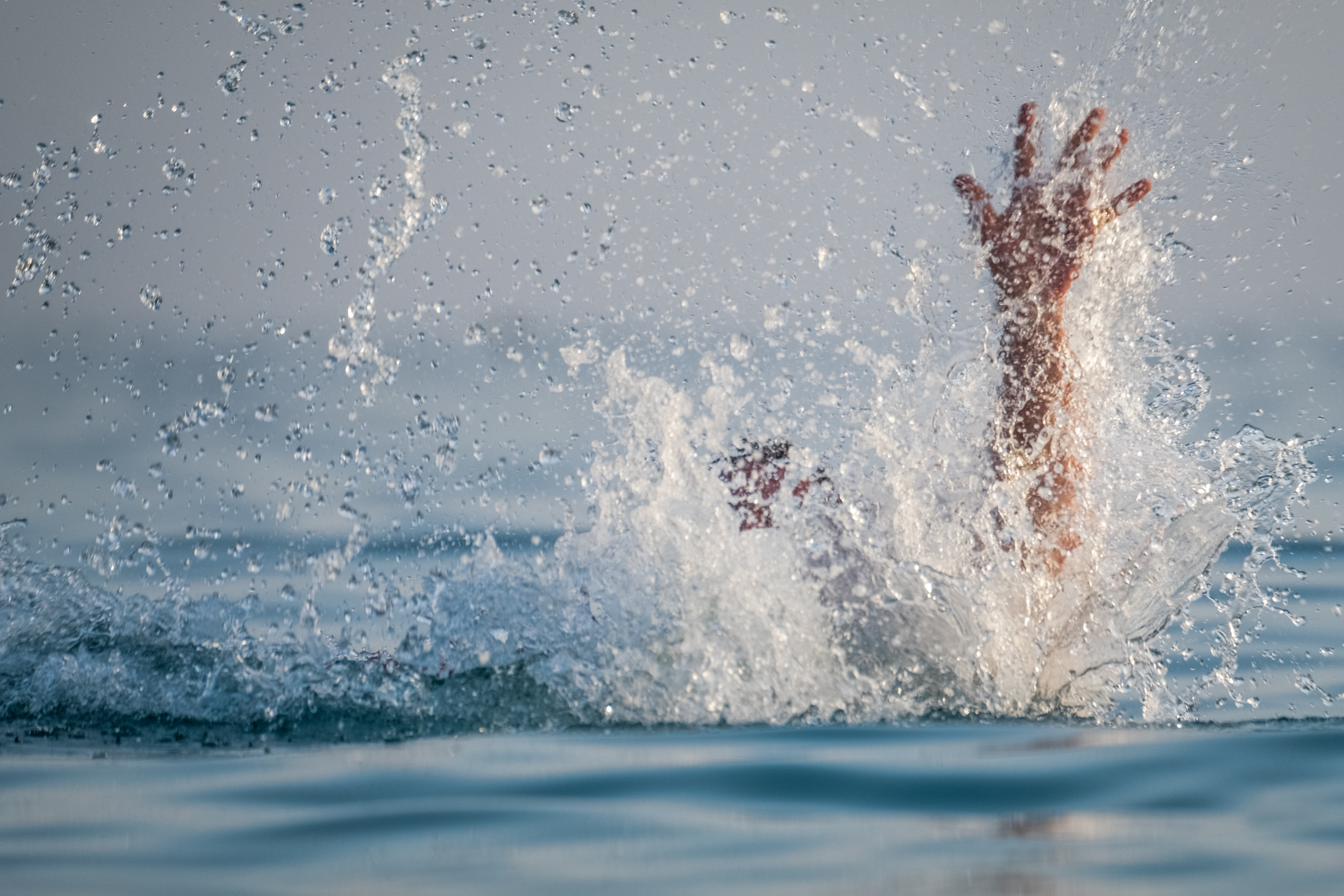 Pessoa pedindo ajuda desde a água | Fonte: Shutterstock
