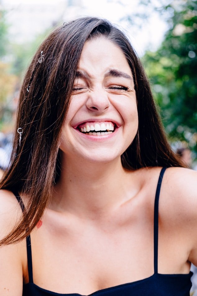 Une jeune femme au sourire éclatant. l Source : Unsplash