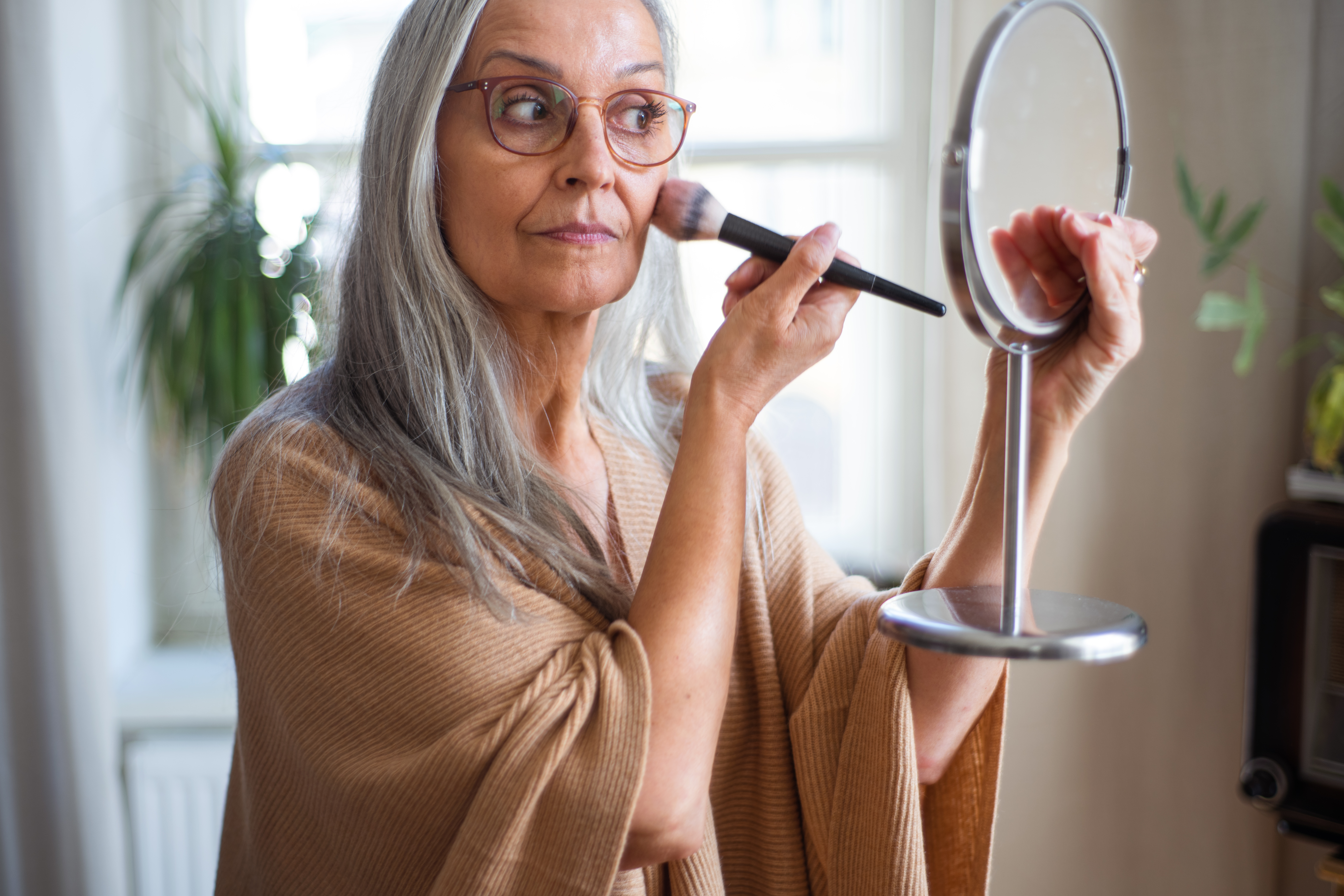 Une femme âgée en train de se maquiller | Source : Getty Images