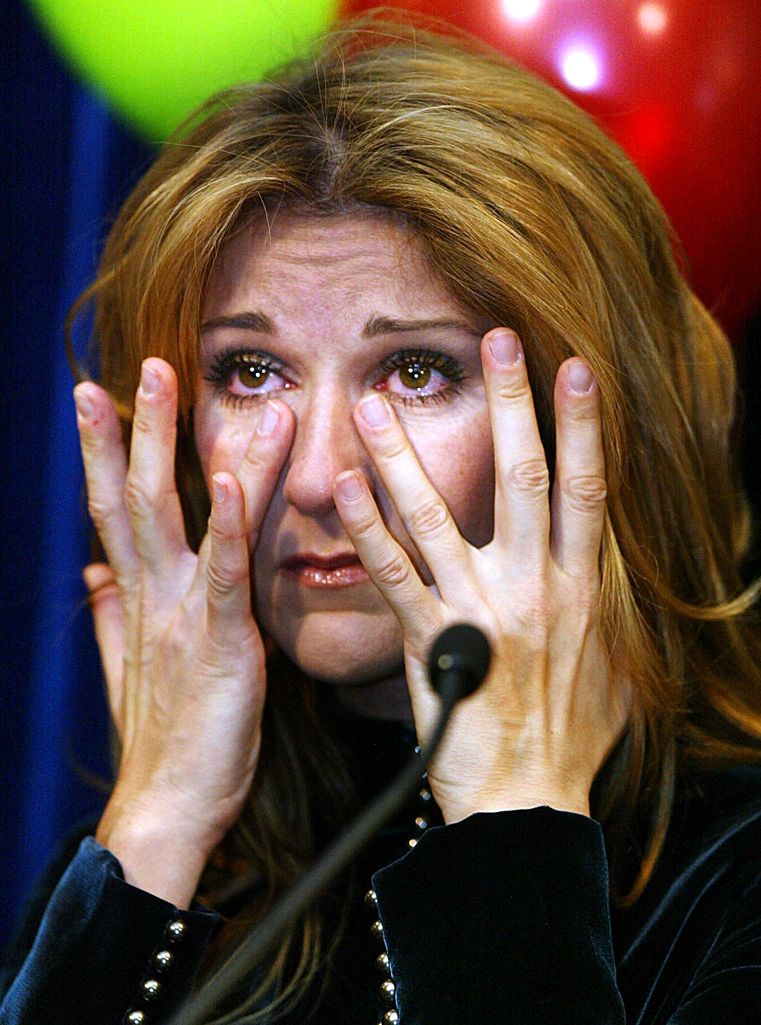 Céline Dion essuie des larmes lors d'un discours à l'hôpital pour enfants Sainte-Justine à Montréal, Canada, le 18 décembre 2002. | Source : Getty Images