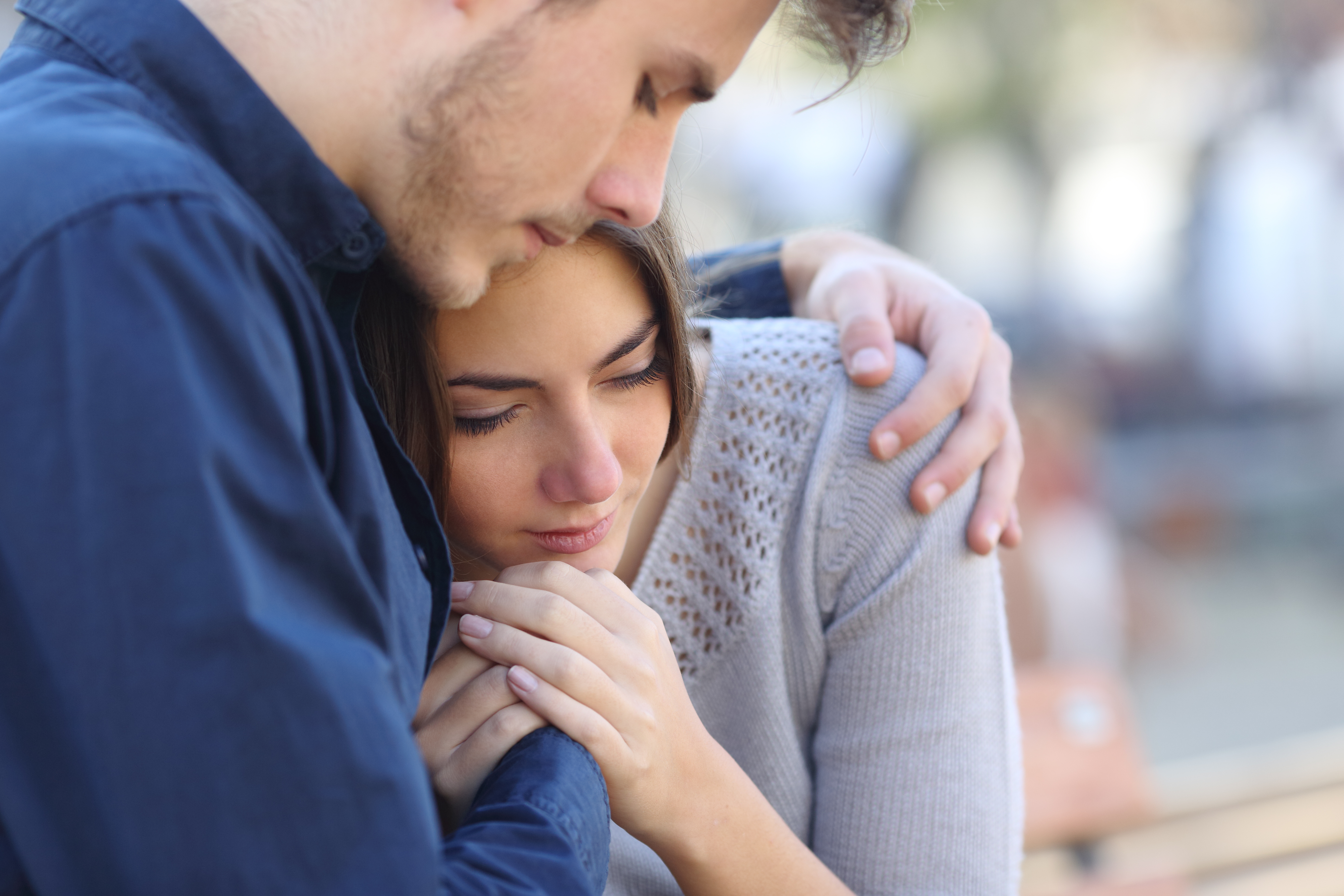Un hombre abraza a su novia triste | Fuente: Shutterstock.com