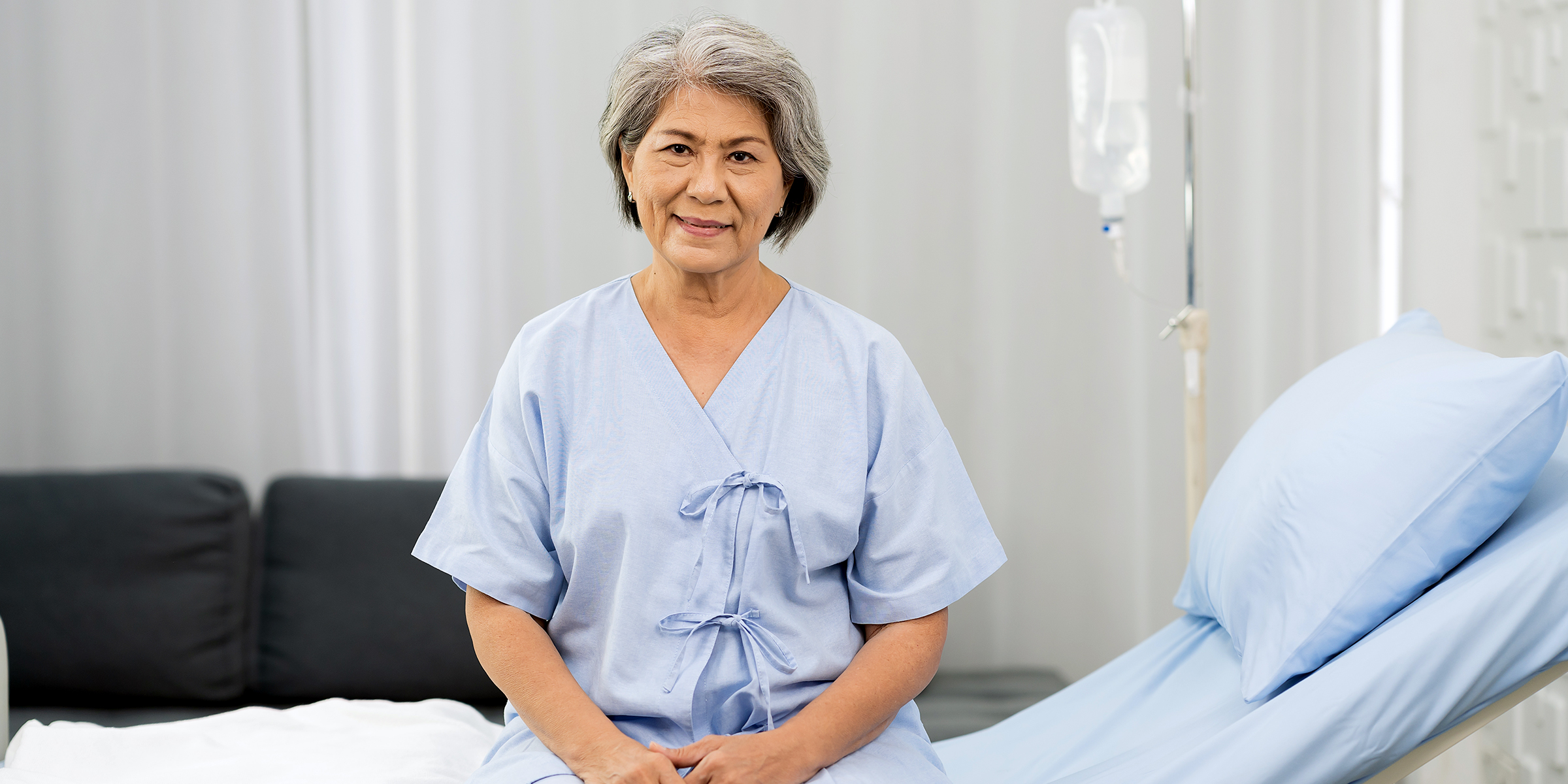 Une femme âgée assise sur un lit d'hôpital | Source : Shutterstock