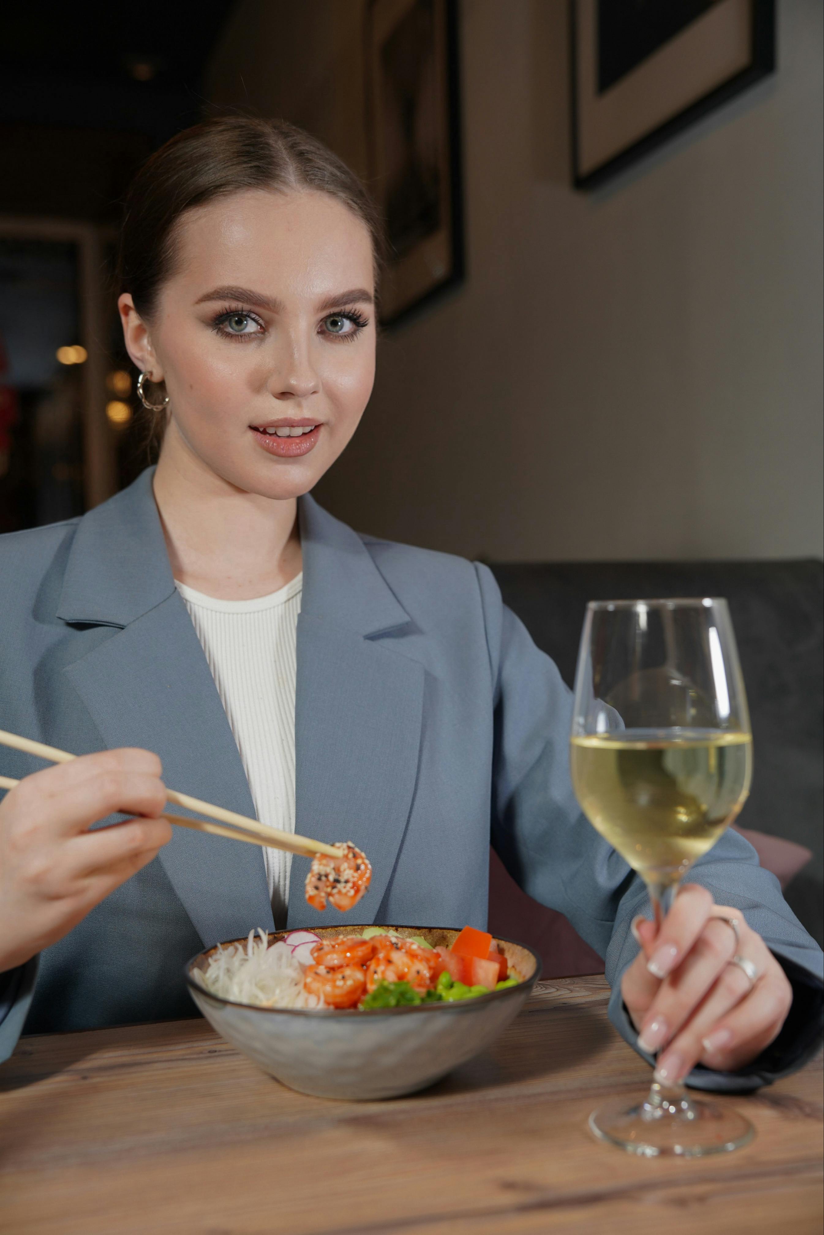 Une jeune femme mangeant un repas avec des baguettes | Source : Pexels