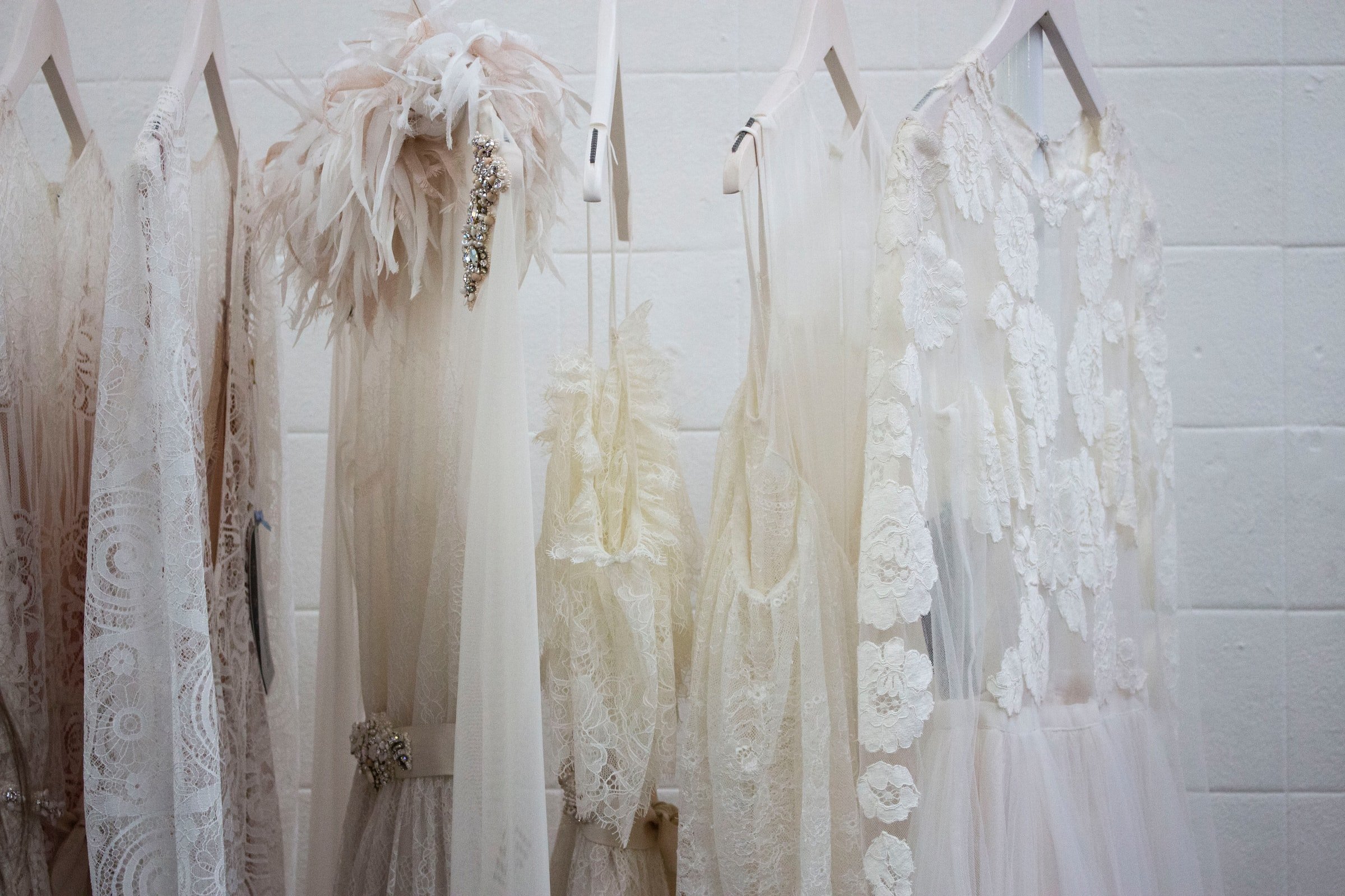 Robes blanches suspendues sur un support | Source : Unsplash