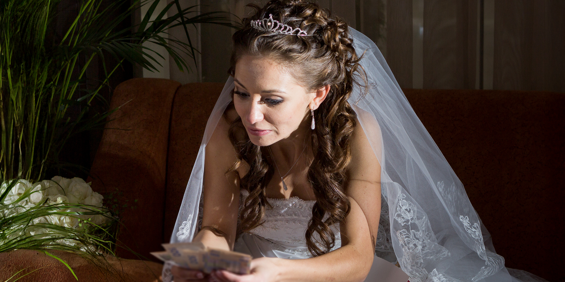 Une mariée tenant de l'argent liquide | Source : Shutterstock