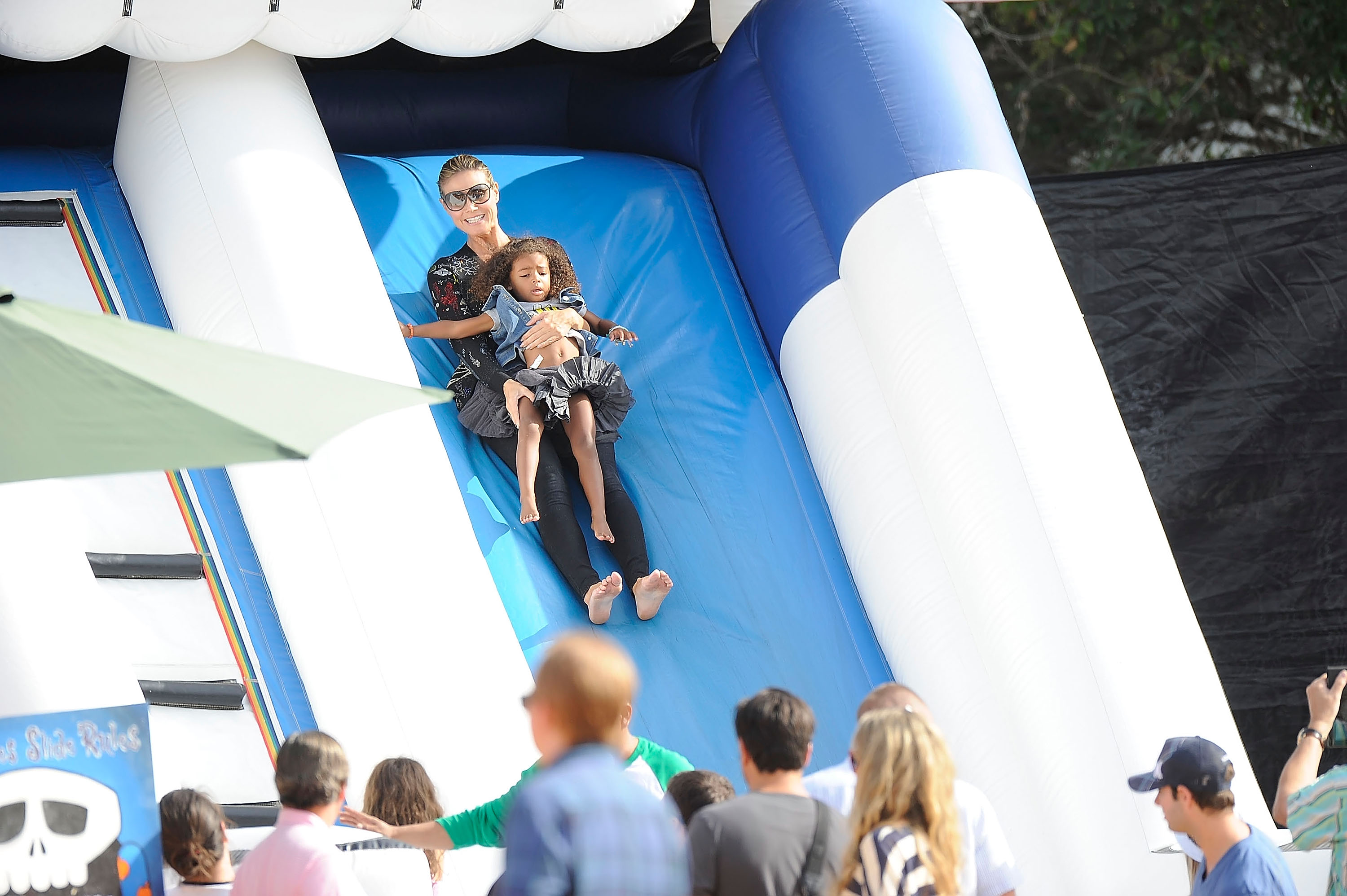 Heidi Klum vue en train de descendre un toboggan de château gonflable avec sa fille Lou Samuel au champ de citrouilles Mr. Bones, le 6 octobre 2012, à Los Angeles, en Californie. | Source : Getty Images