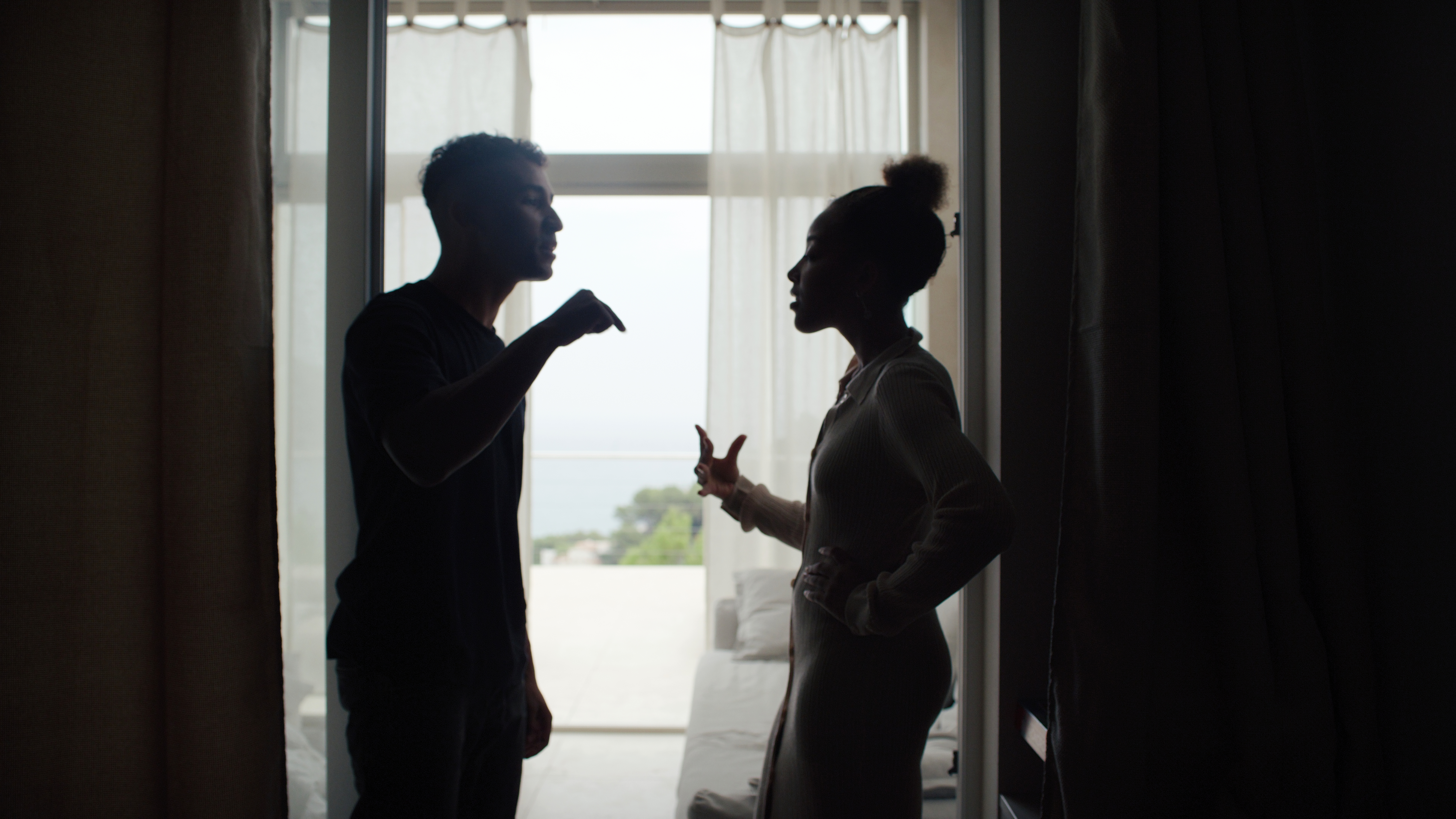 Couple malheureux se disputant et faisant des gestes dans le salon. Crise relationnelle | Source : Getty Images