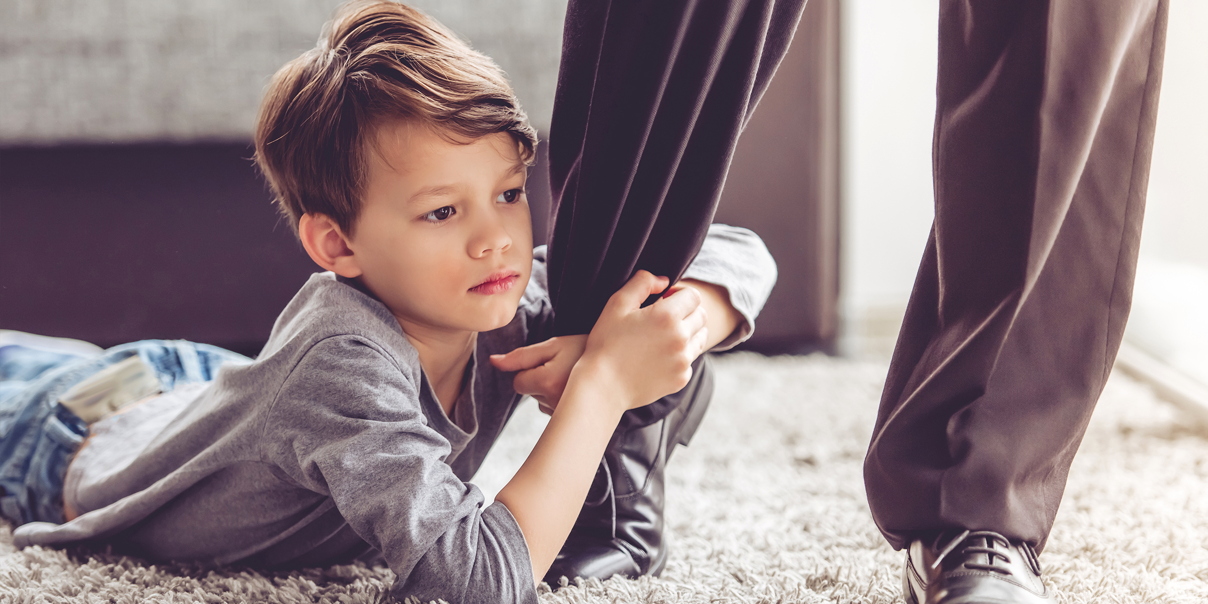 Un enfant qui s'accroche à la jambe d'un adulte | Source : Shutterstock