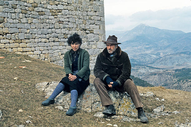 Liliane Rovère et Christian Barbier assis sur une pierre | Sources : Getty Images 