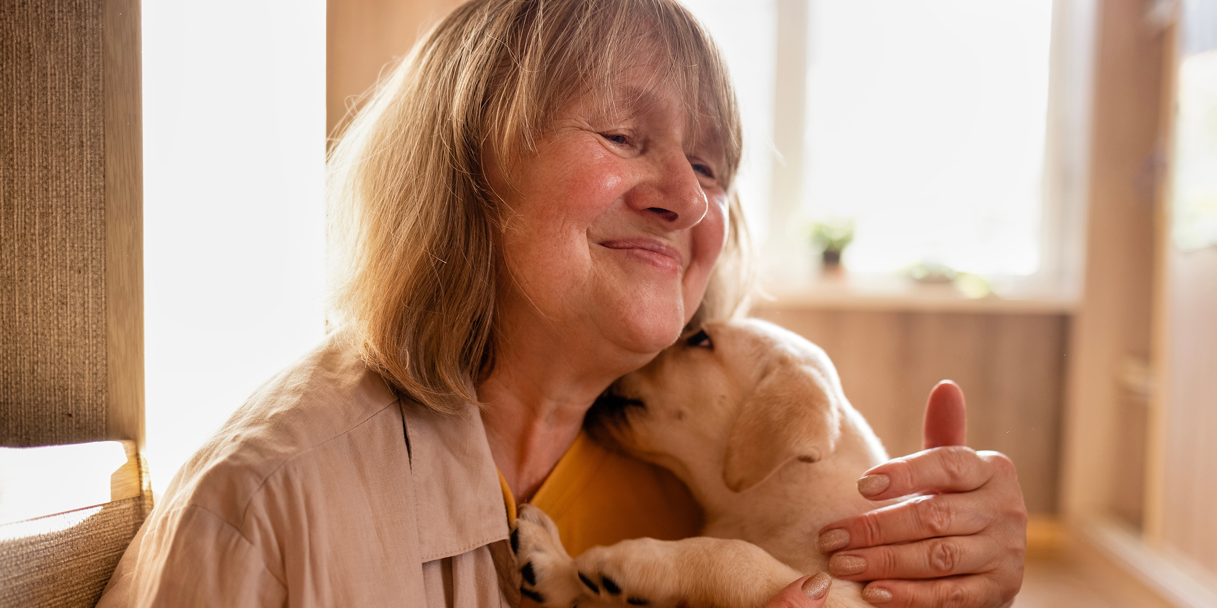 Une femme âgée câlinant un chien | Source : Shutterstock