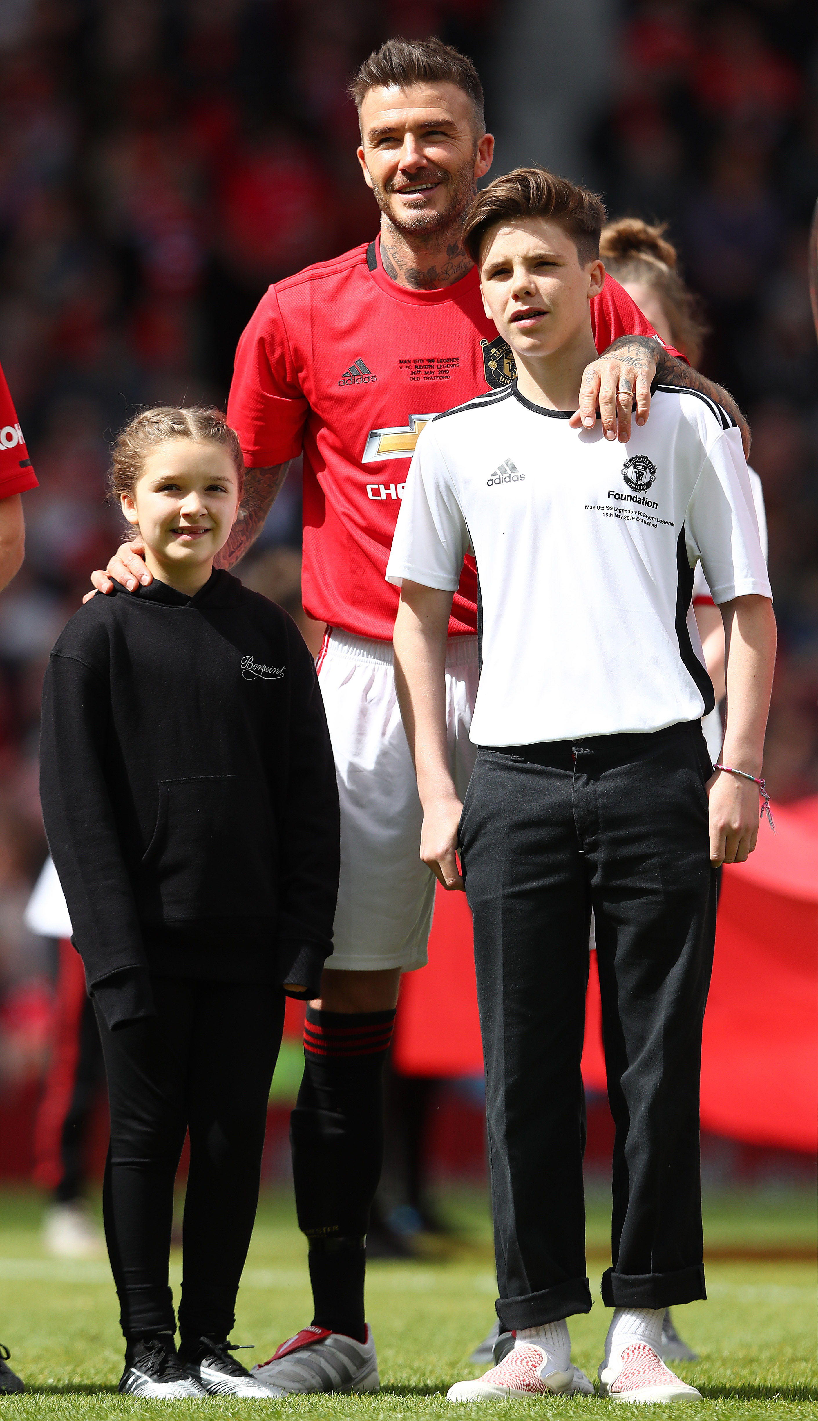 David Beckham pose avec son fils Cruz et sa fille Harper à Old Trafford en 2019, quand il est remonté sur le terrain pour un match de charité de Manchester United. | Source : Getty Images.