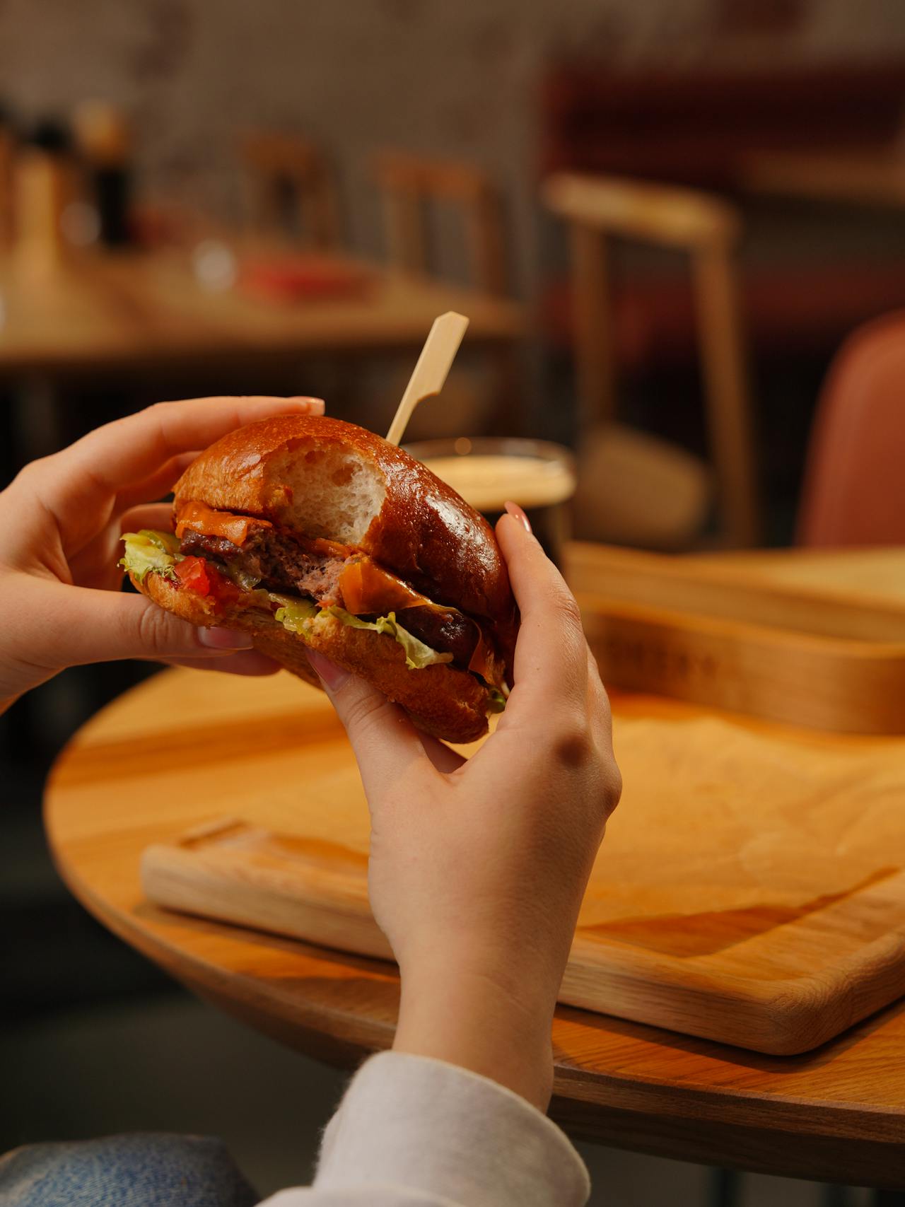 Une femme mangeant un hamburger | Source : Pexels